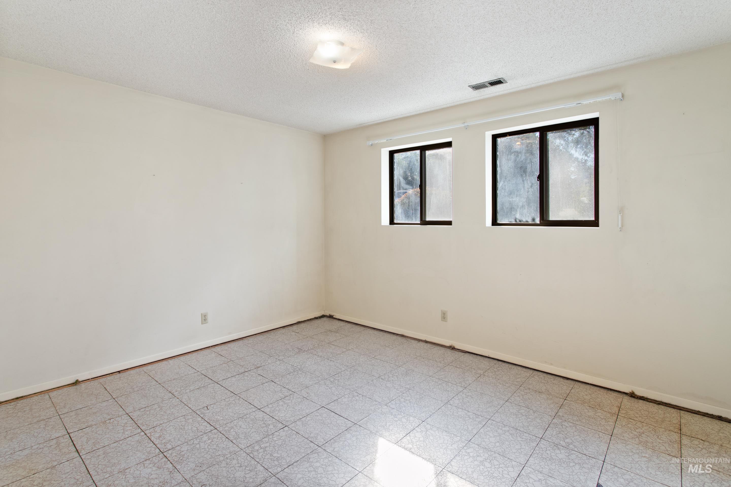 Spare room with a textured ceiling and light floors