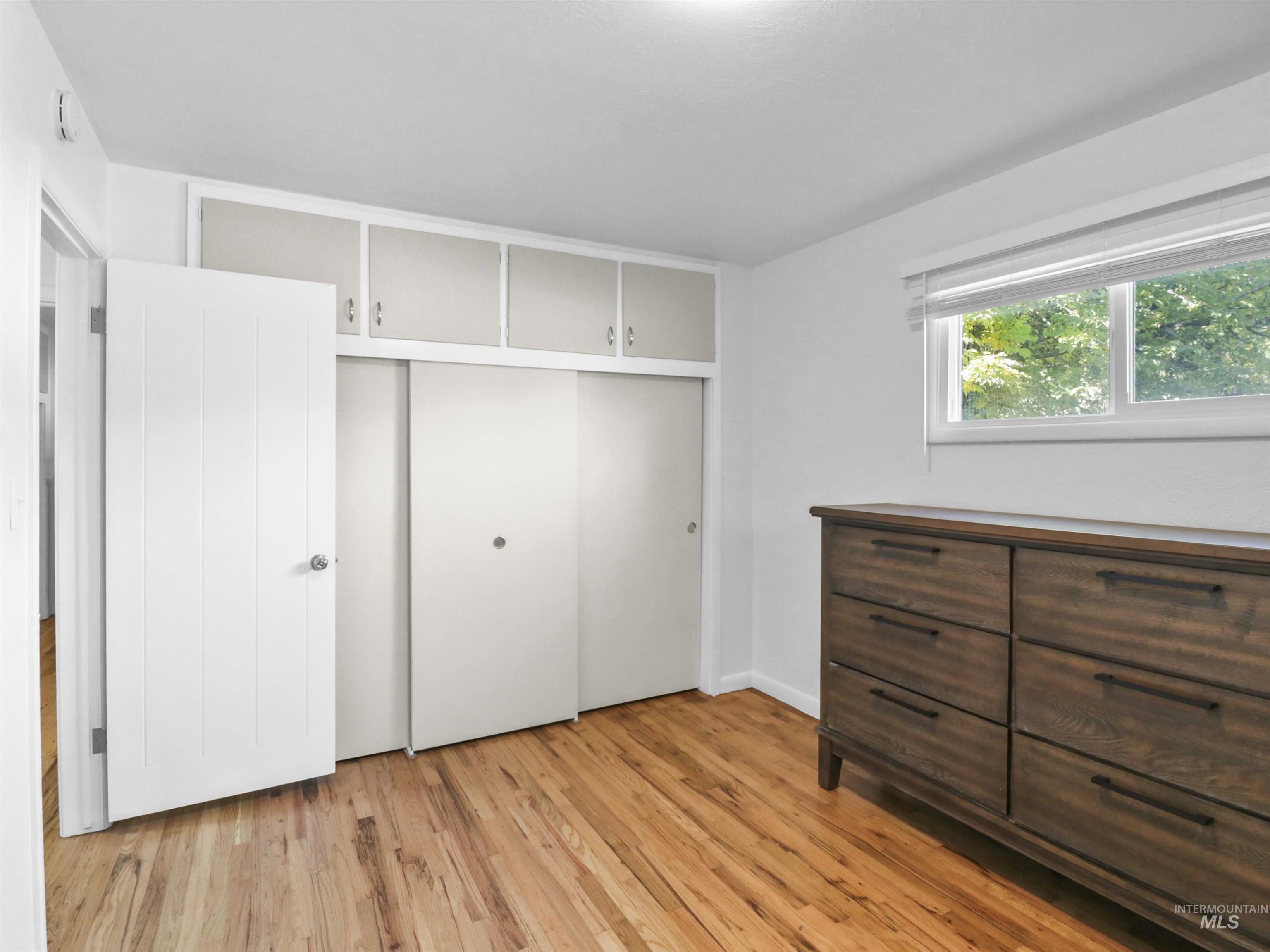 Unfurnished bedroom featuring light wood finished floors and a closet