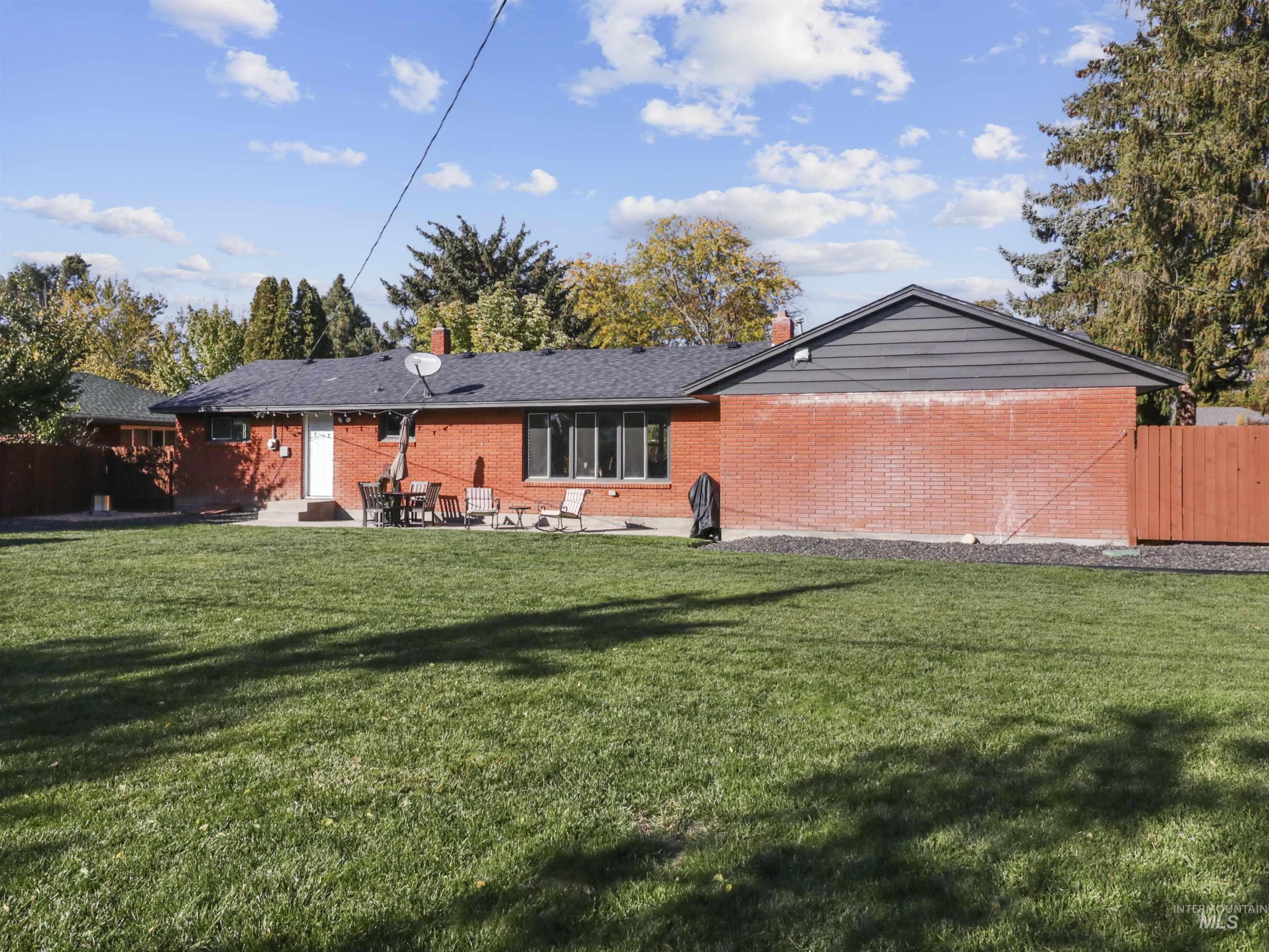 Rear view of property with brick siding, a patio area, and a chimney