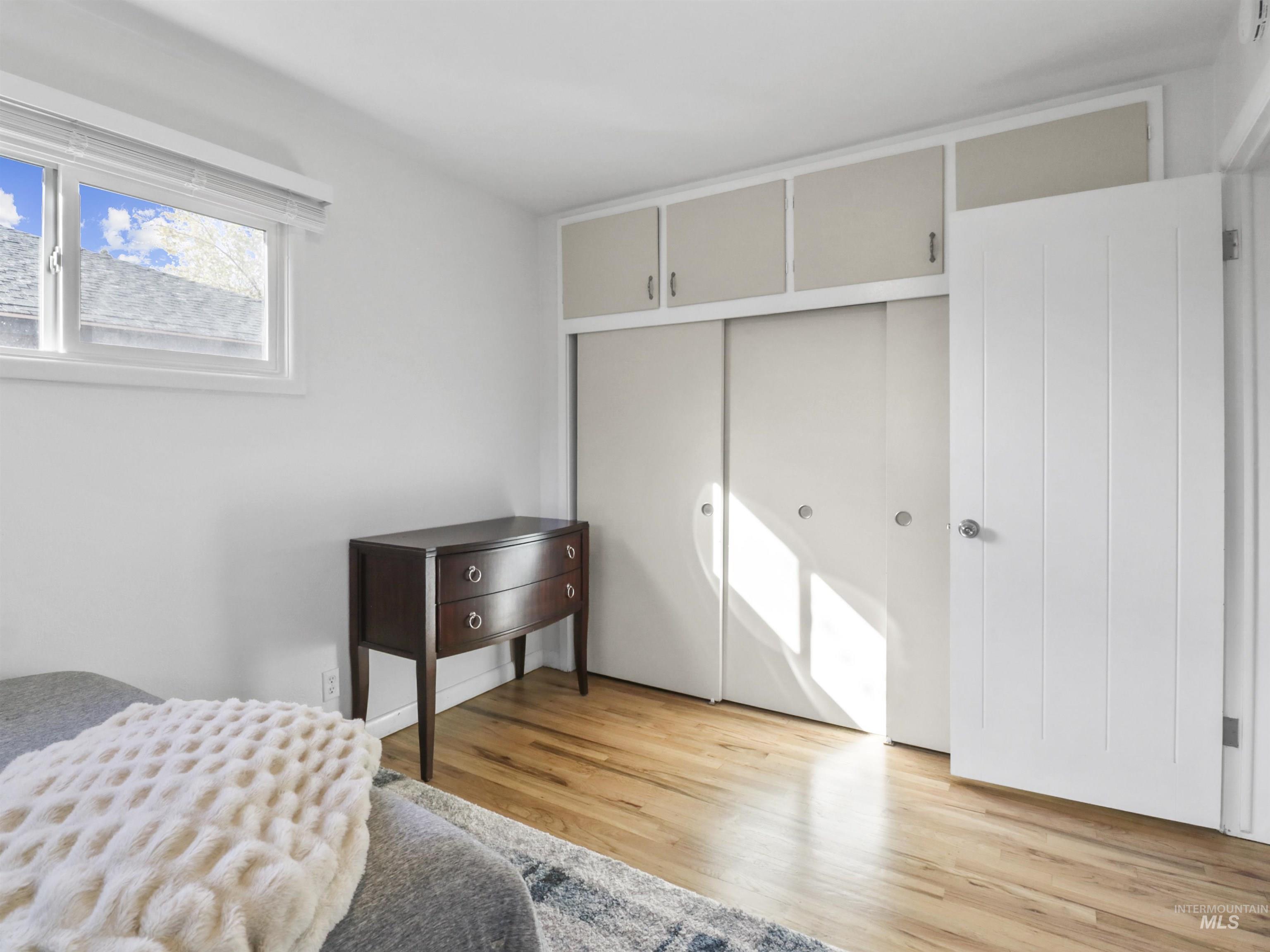 Bedroom with light wood finished floors and a closet