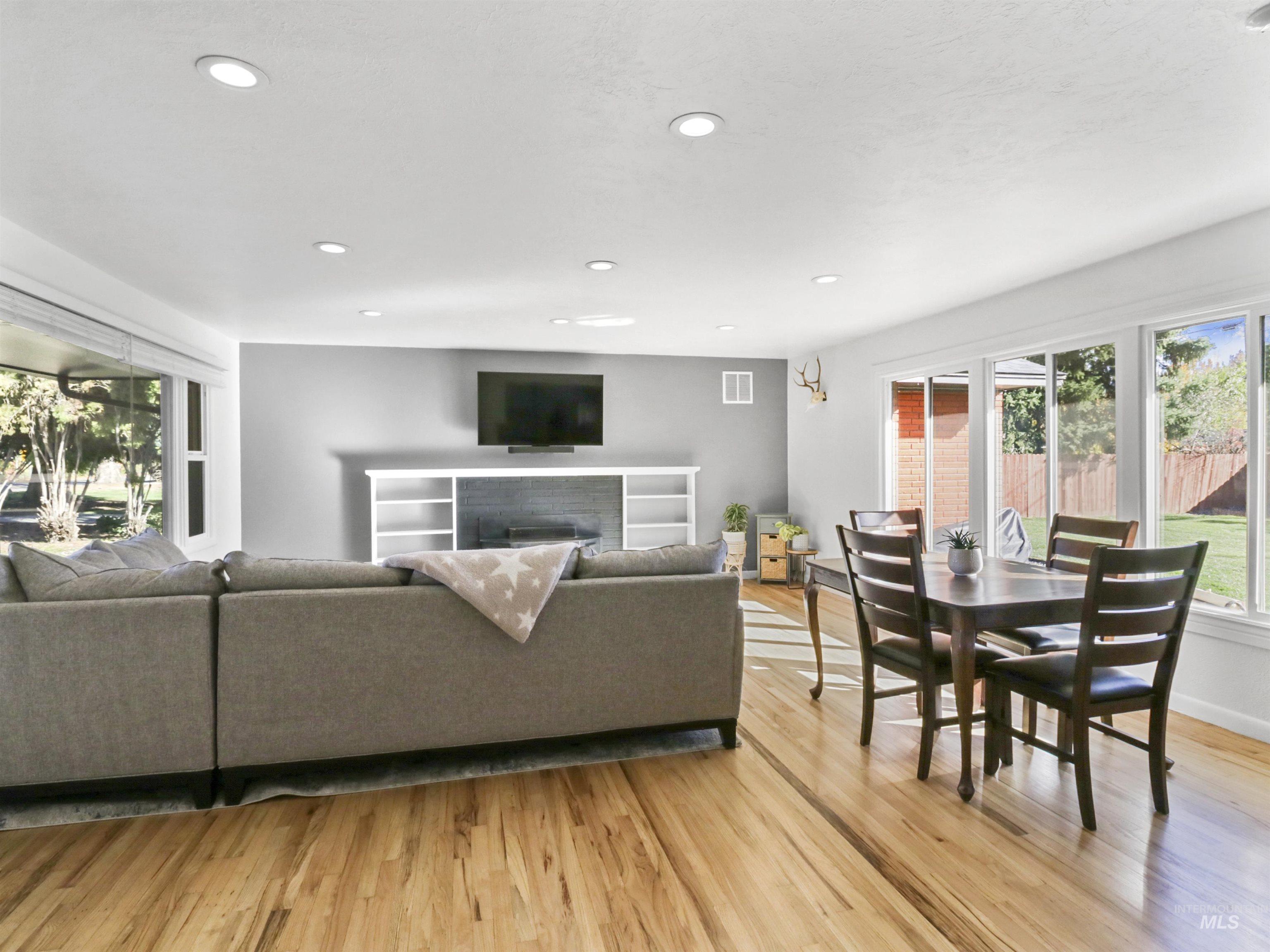 Living area with recessed lighting, light wood finished floors, and a fireplace