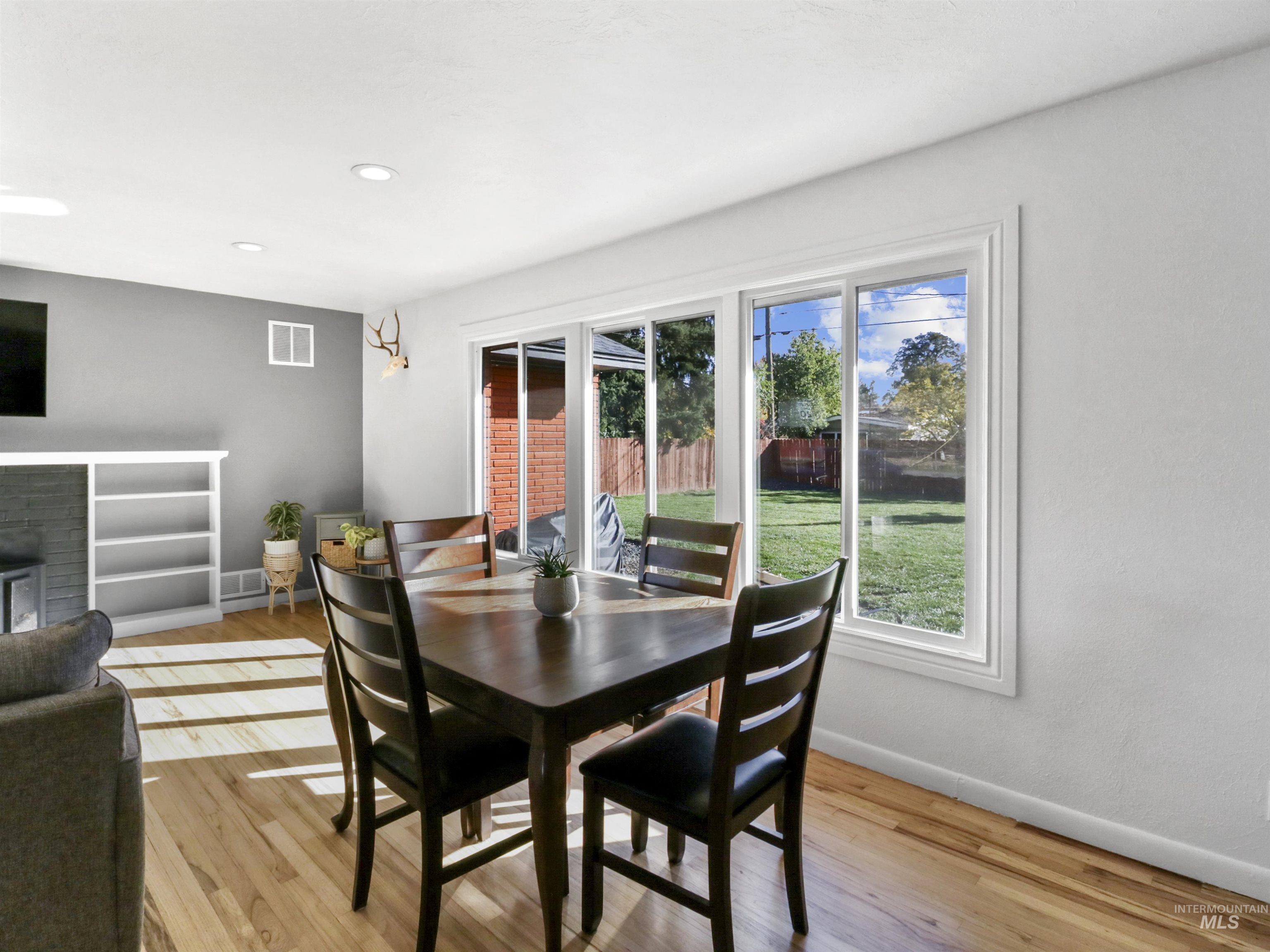 Dining area with light wood-style floors, a fireplace, and recessed lighting
