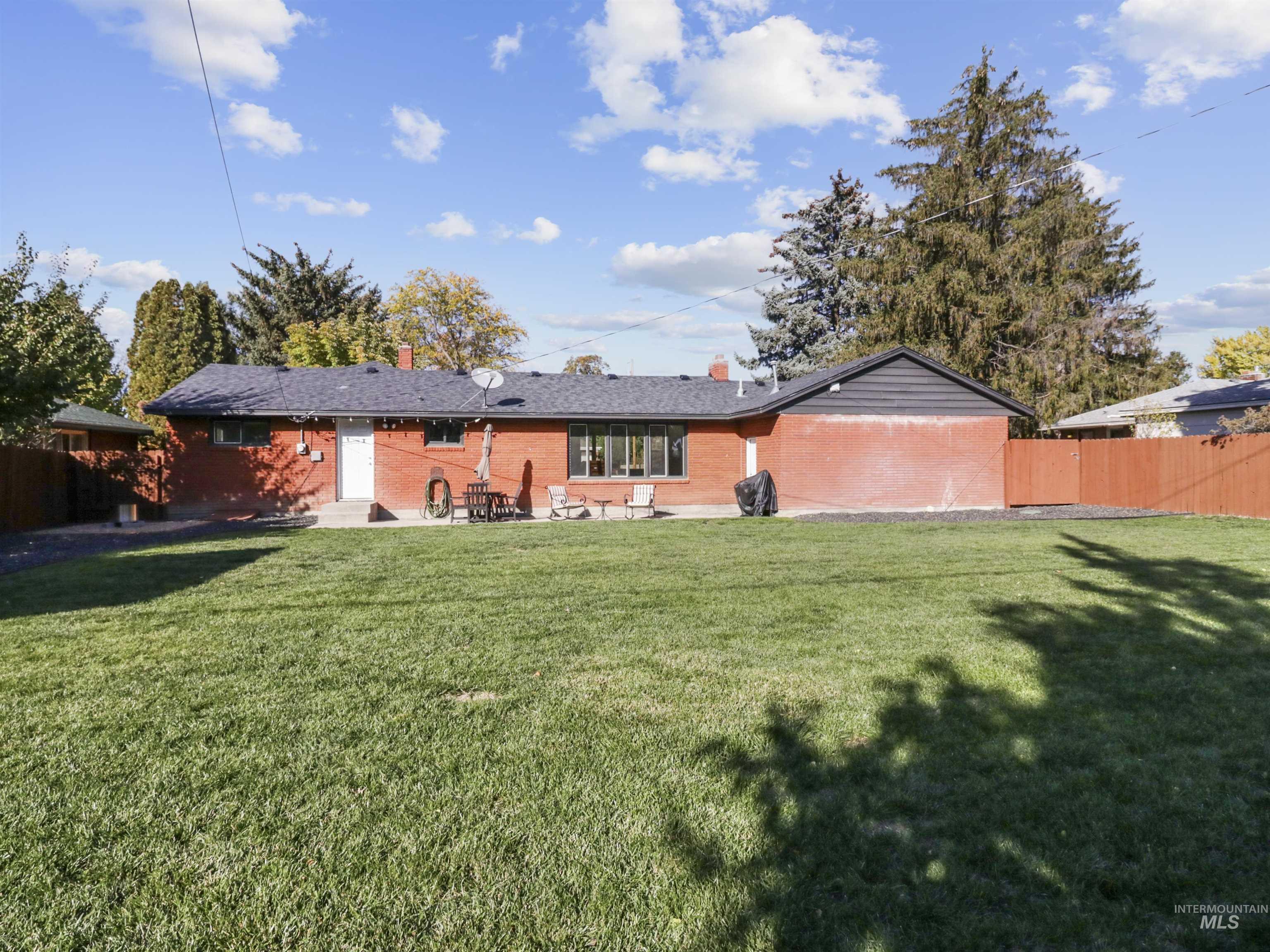 Rear view of property featuring brick siding, a patio area, and a chimney