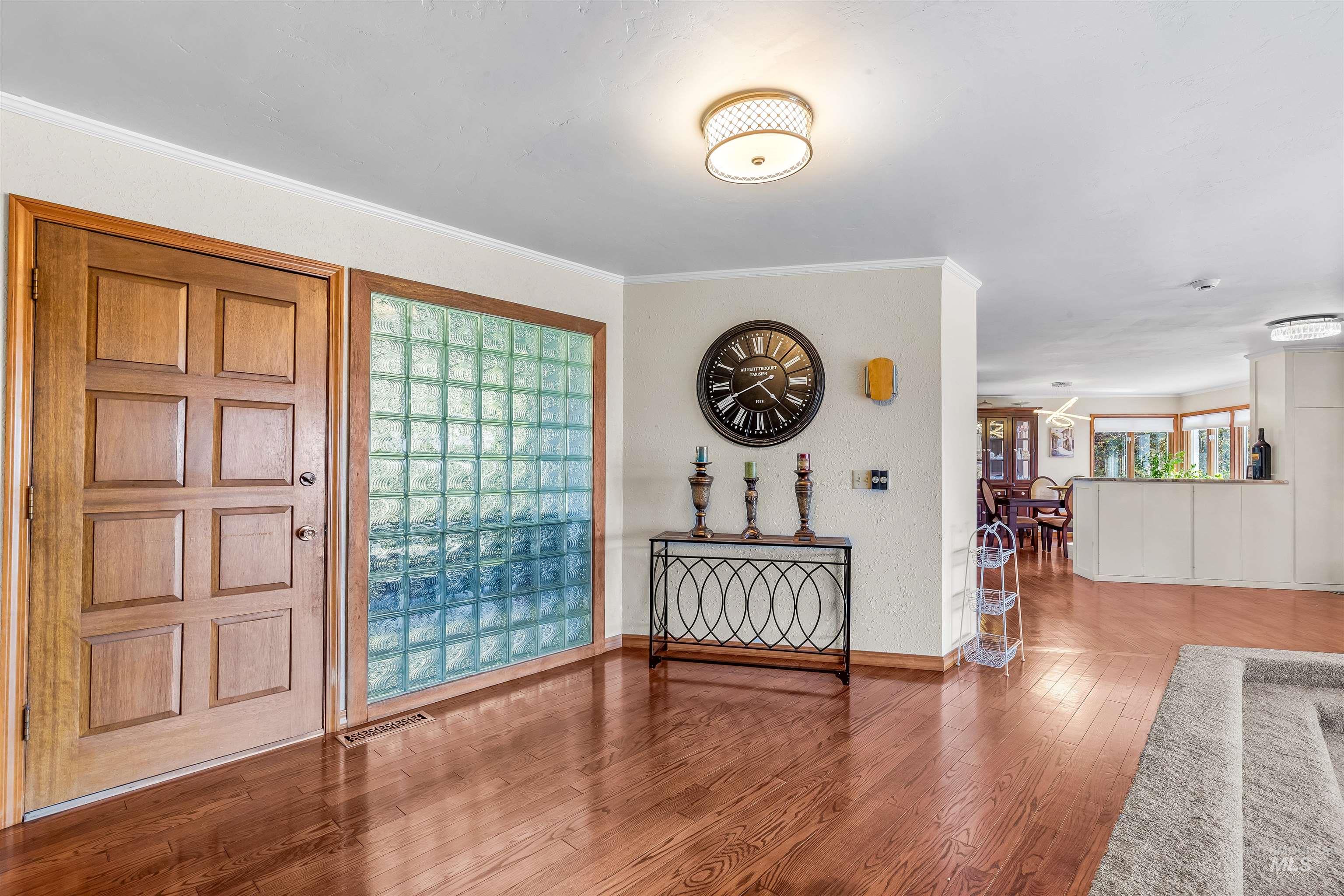 Foyer entrance with wood finished floors and ornamental molding