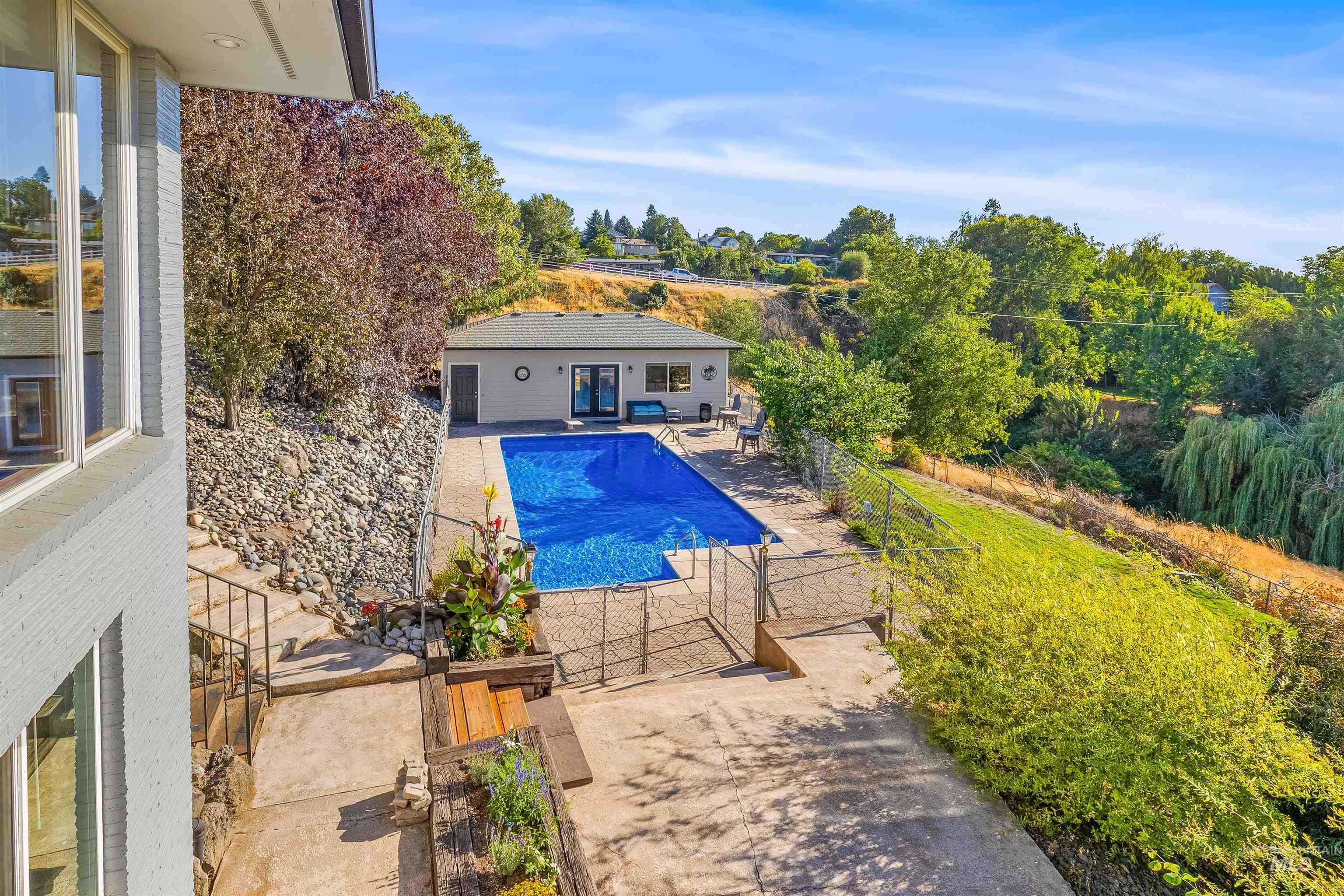 View of pool with a patio and a gate