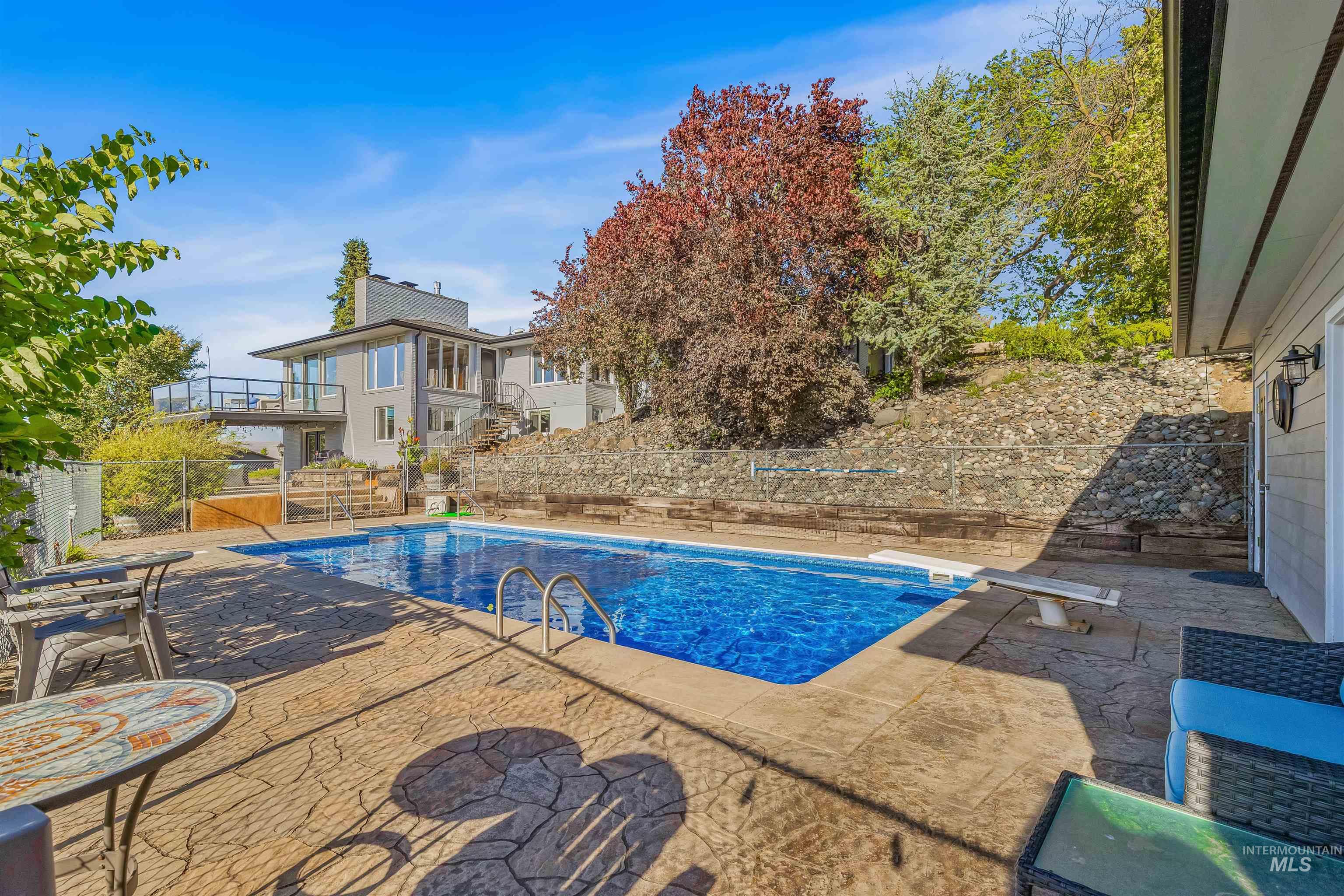View of swimming pool with a patio and a diving board