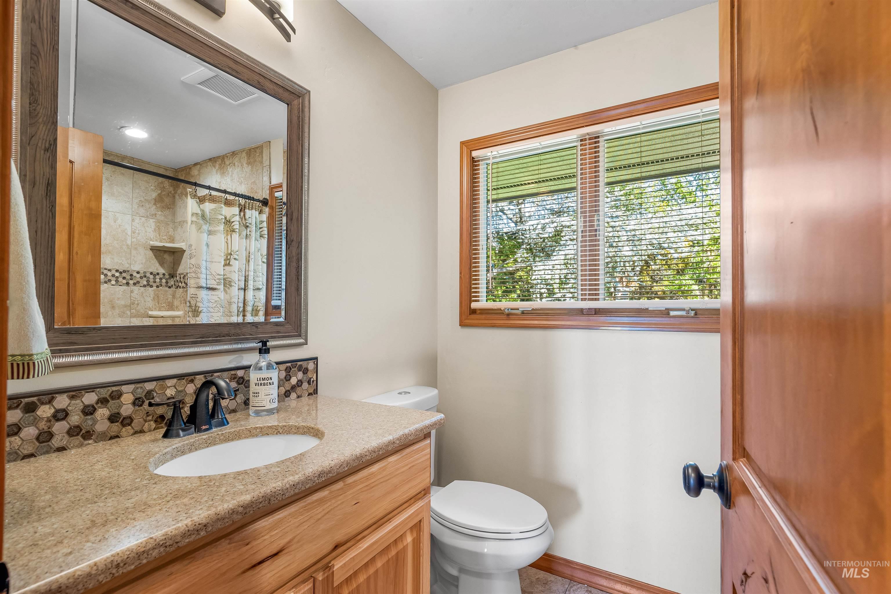 Full bath with vanity and a shower with shower curtain