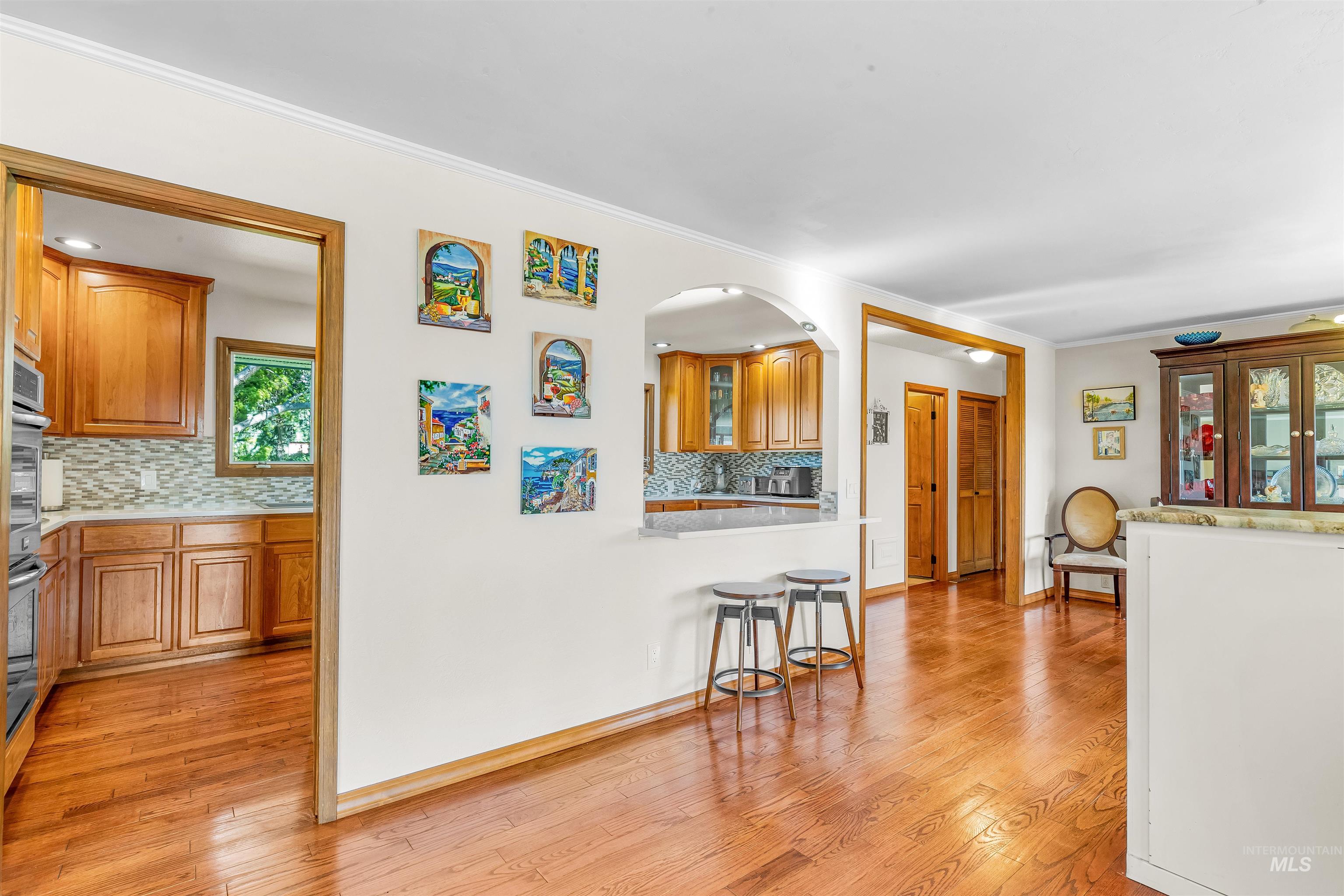 Dining space featuring light wood-style flooring and crown molding
