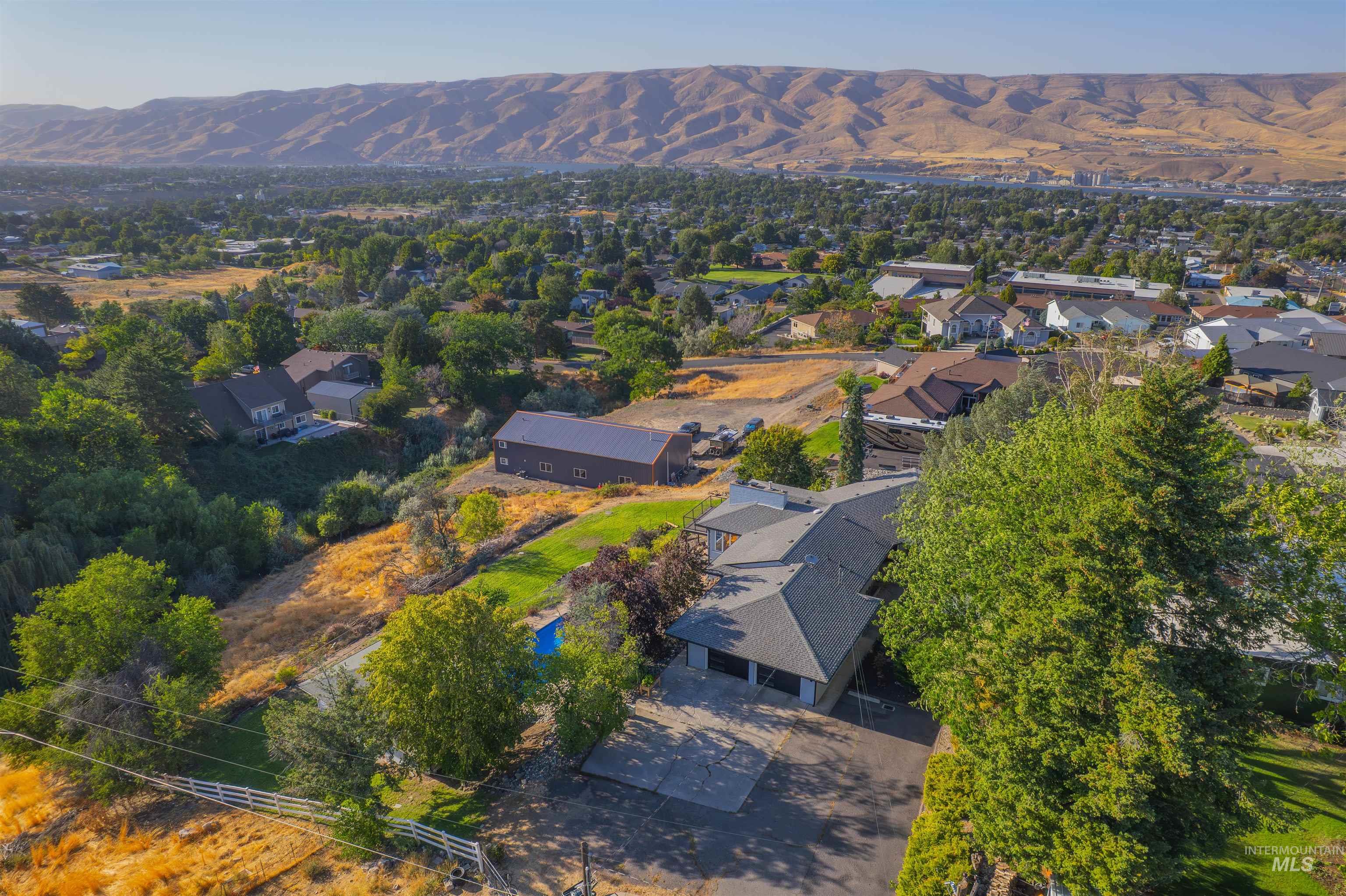 Aerial view of property's location featuring a mountainous background and nearby suburban area