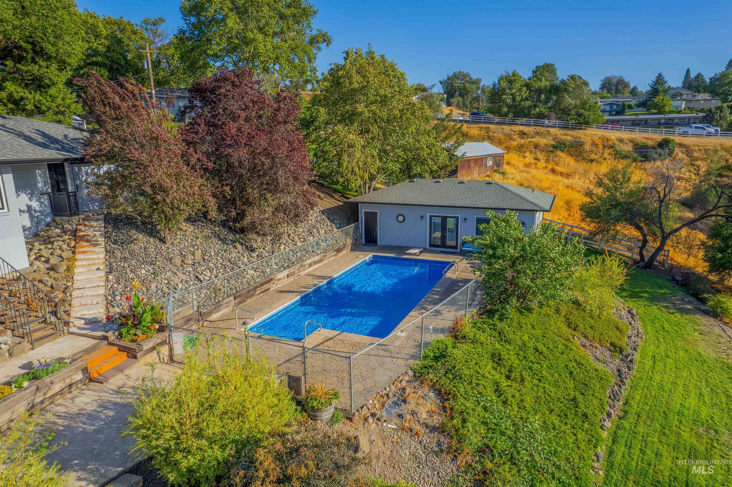 View of swimming pool with a fenced backyard, a patio, and view of wooded area