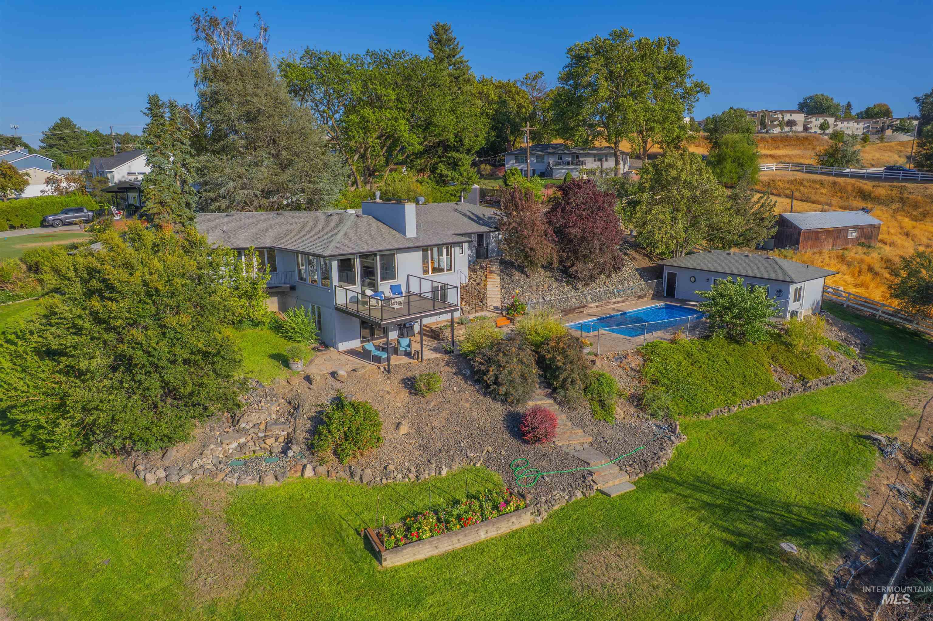 Aerial view of property and surrounding area featuring a pool area