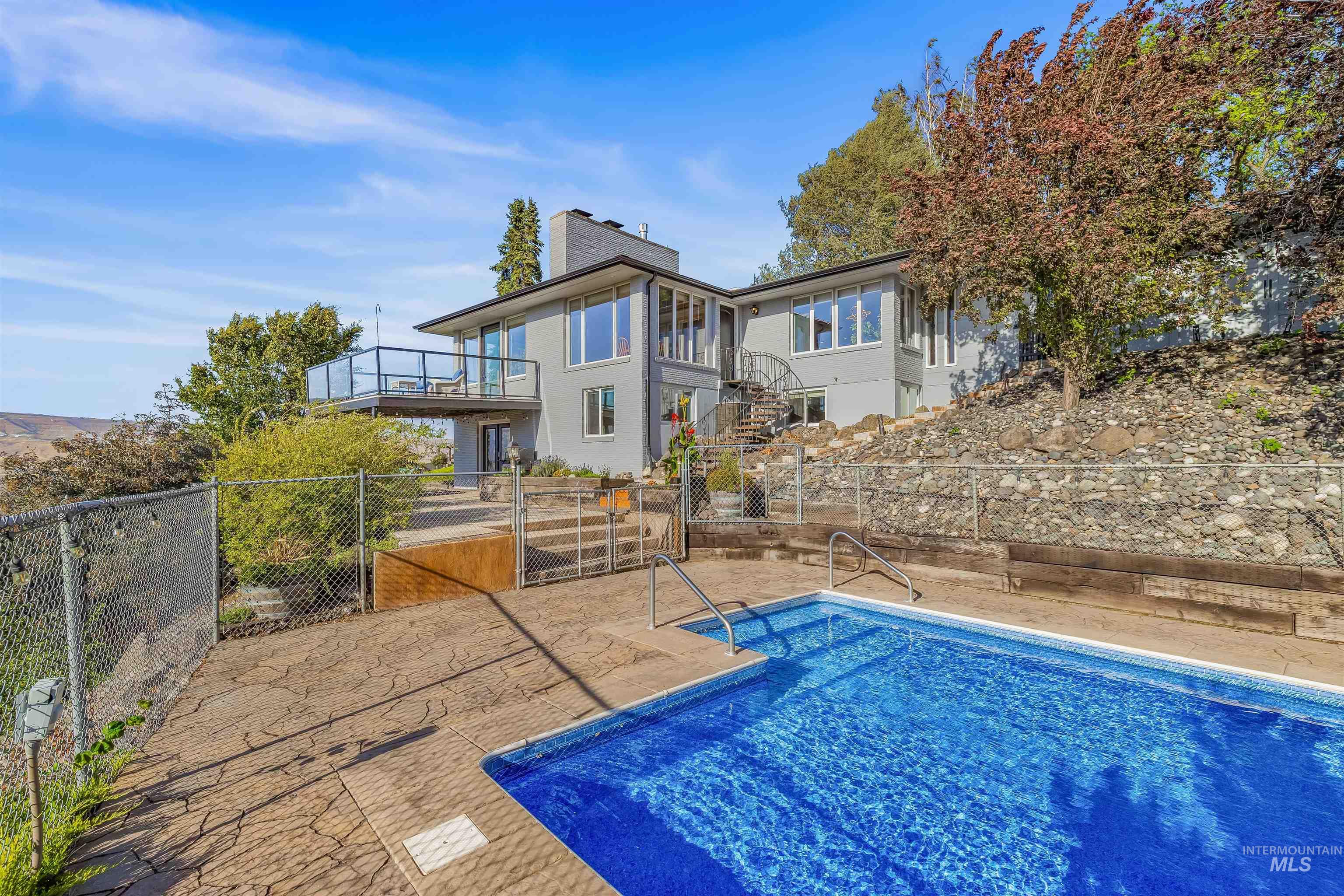 View of swimming pool featuring stairs, a balcony, and a patio