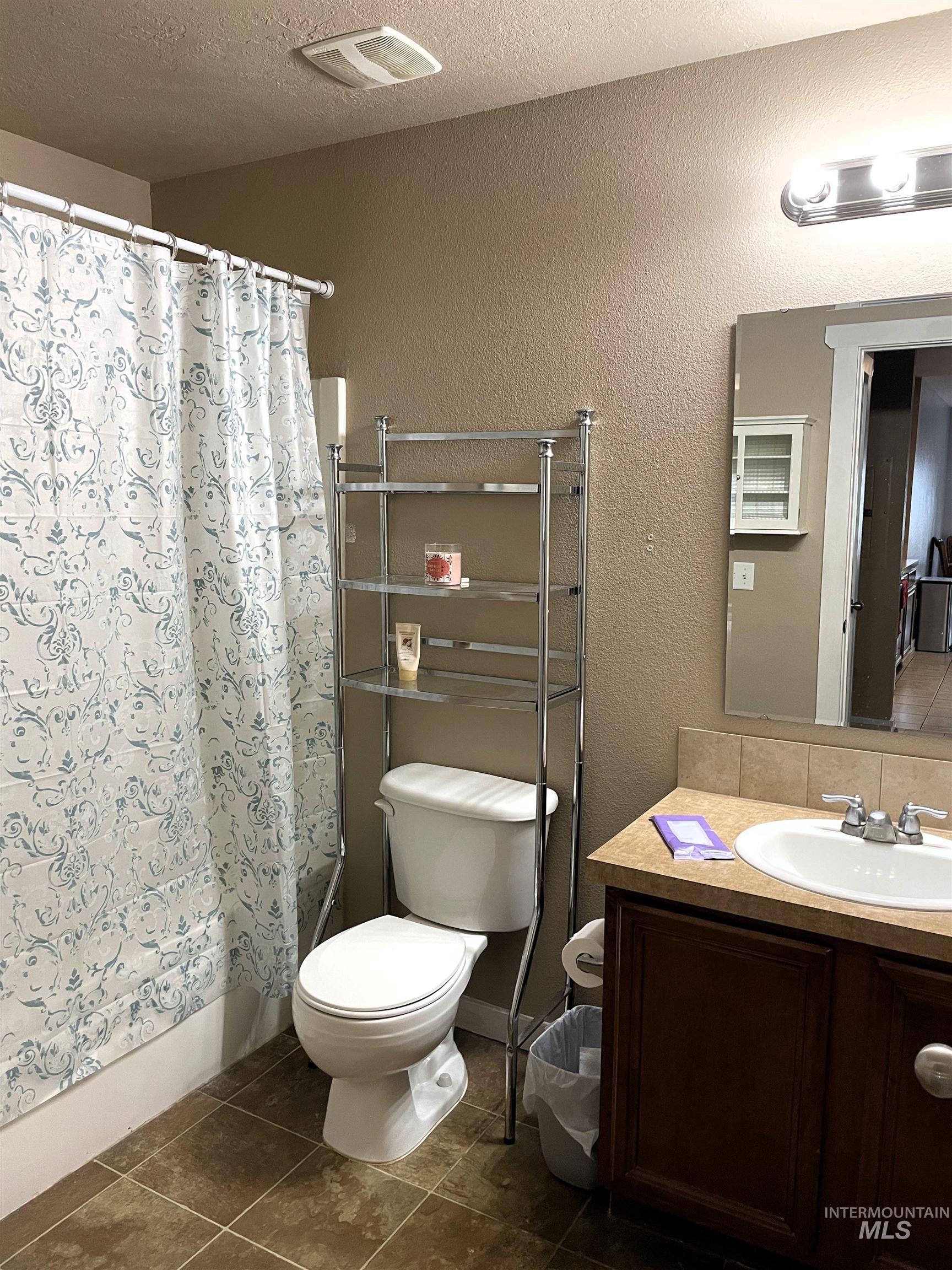 Bathroom featuring a vanity with a white sink, chrome faucet, and dark wood-finish cabinetry