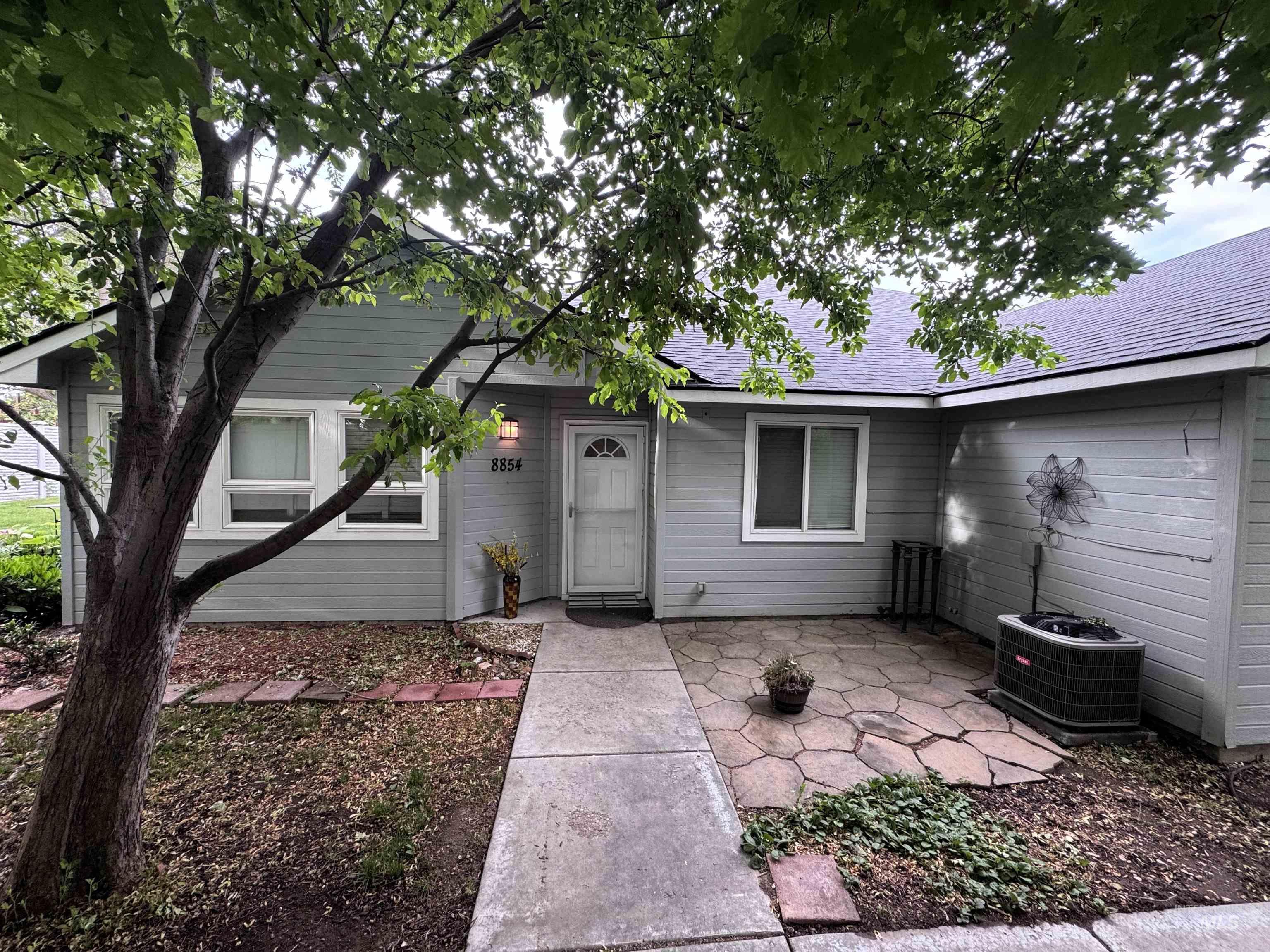 Light gray exterior siding with white window trim and a complementary white entry door