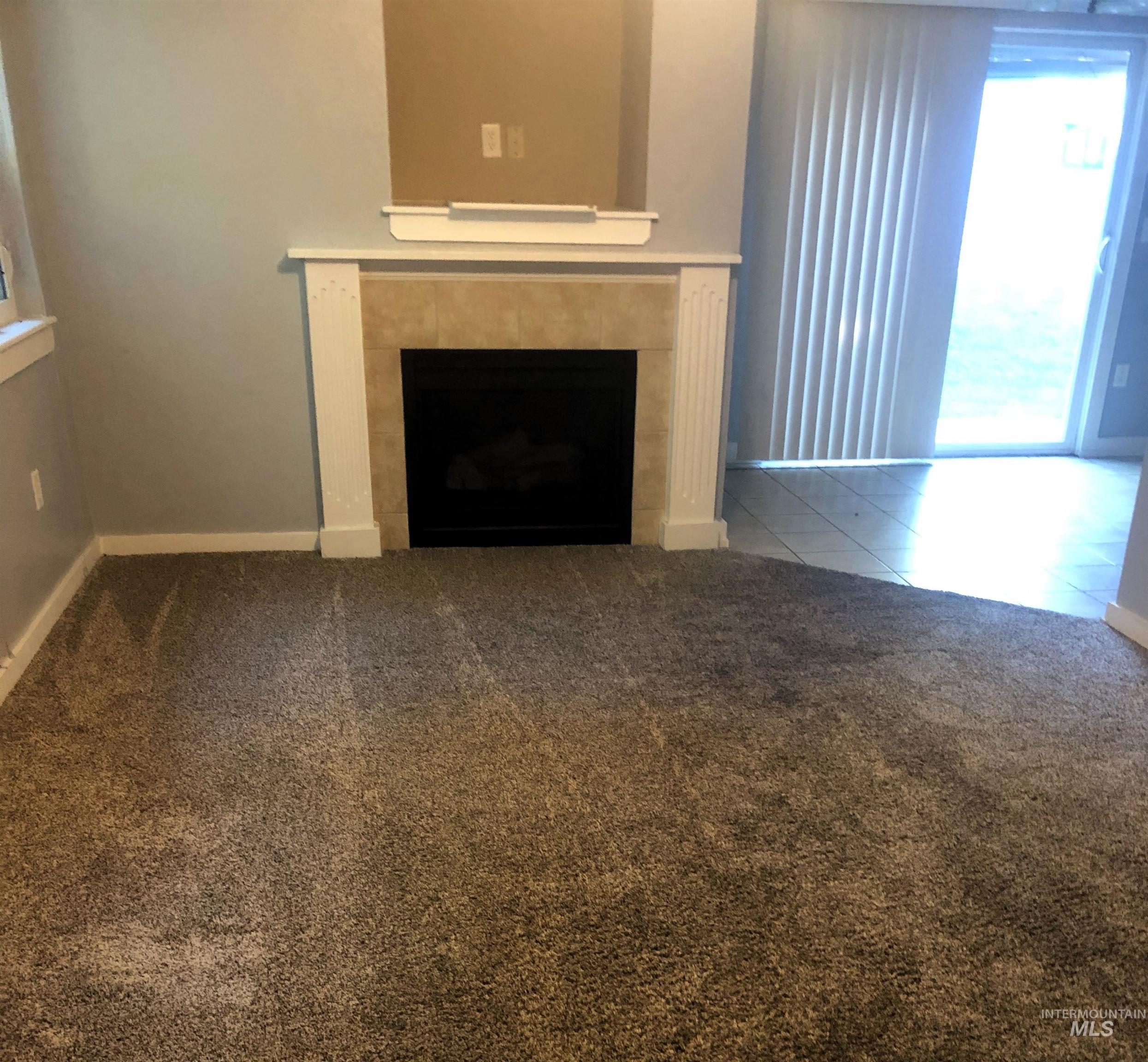 Fireplace featuring a tiled surround and white mantel with decorative fluted pilasters