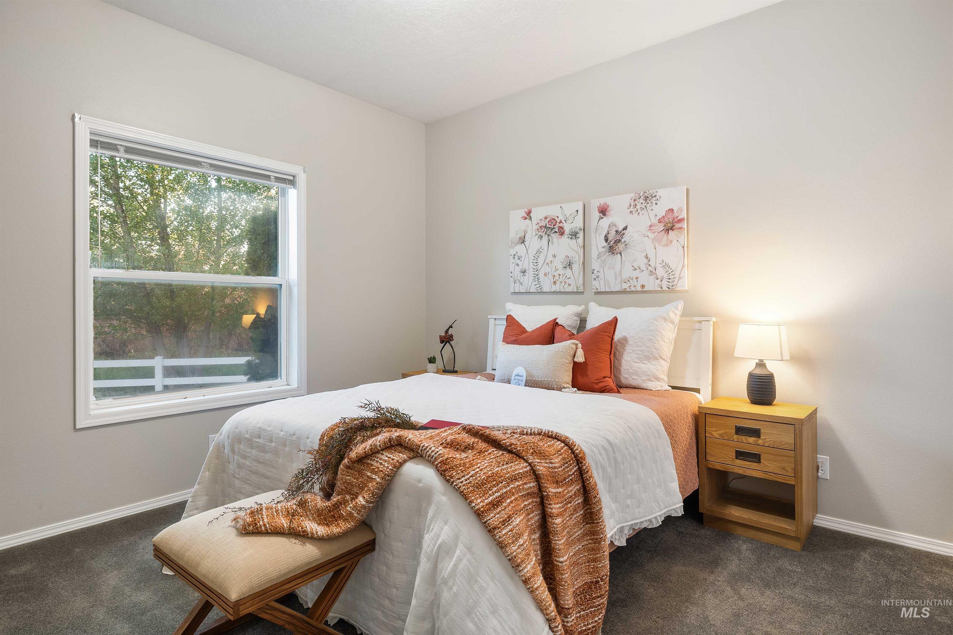 Bedroom featuring neutral paint, carpeted flooring, a white-framed window, and white baseboards