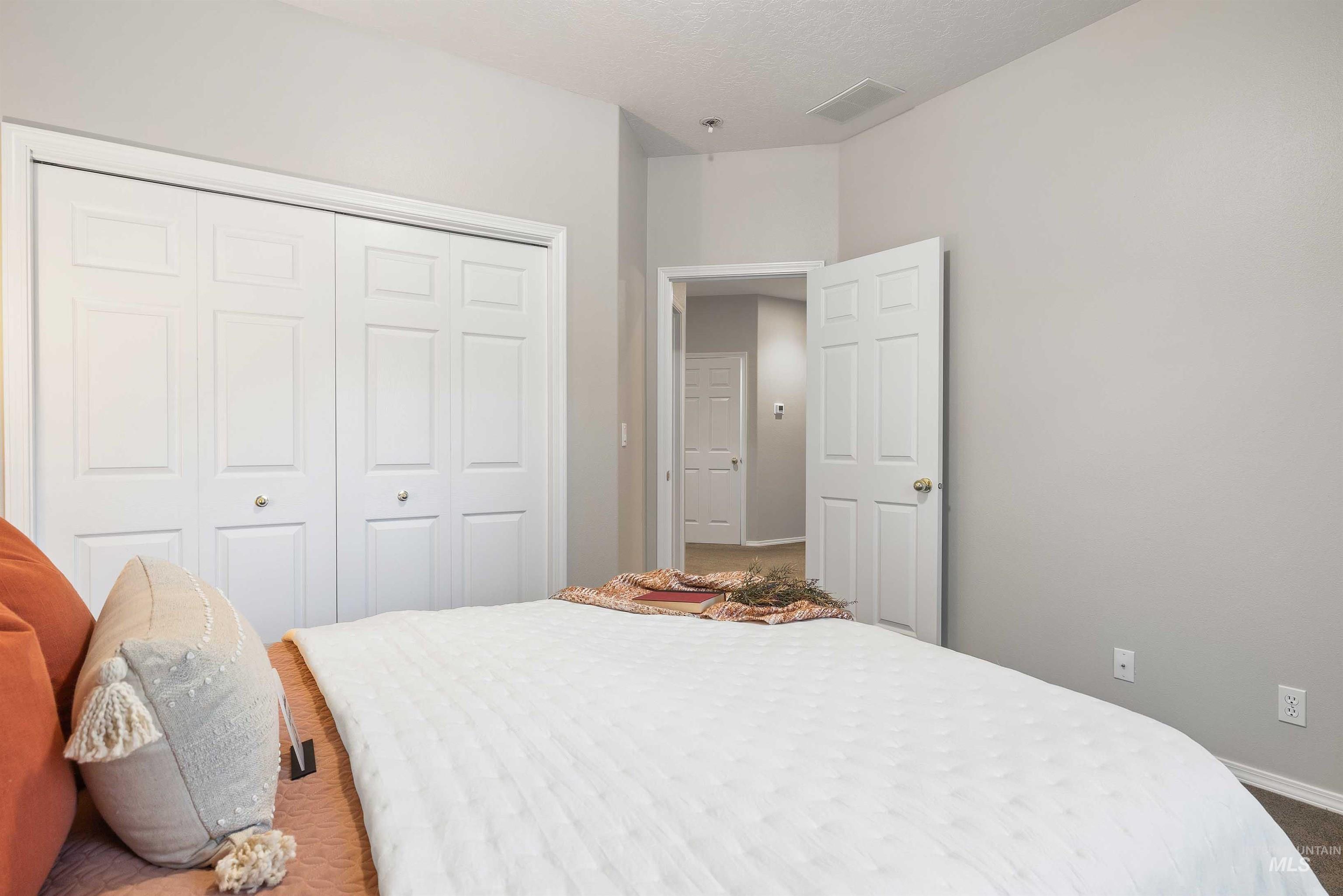 Recessed lighting illuminates this room, featuring a white bi-fold closet and a white paneled door