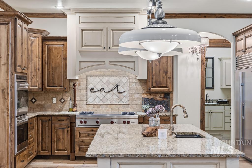 Gourmet kitchen featuring a substantial island with an undermount sink and a gooseneck faucet