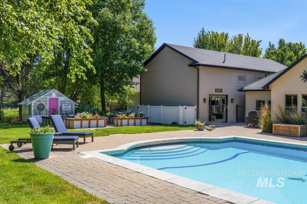Backyard oasis featuring an in-ground swimming pool, paver patio, and lush green lawn
