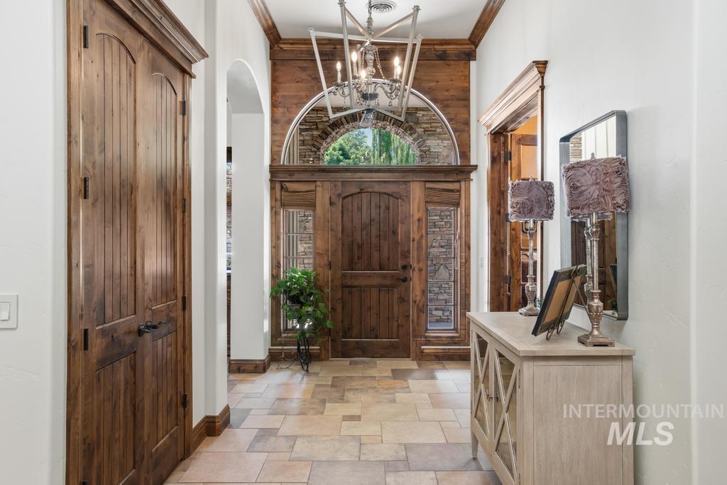 Grand entry featuring a solid wood door with sidelights, an arched transom, and stone accents
