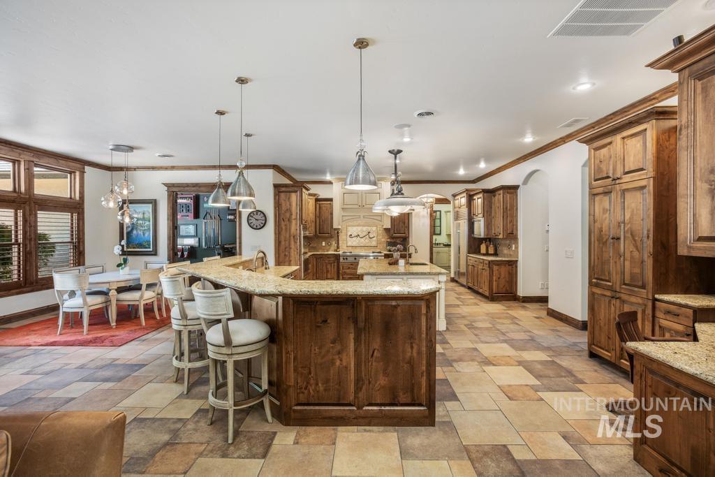 Spacious kitchen with a multi-toned tile floor, extensive wood cabinetry, and recessed lighting