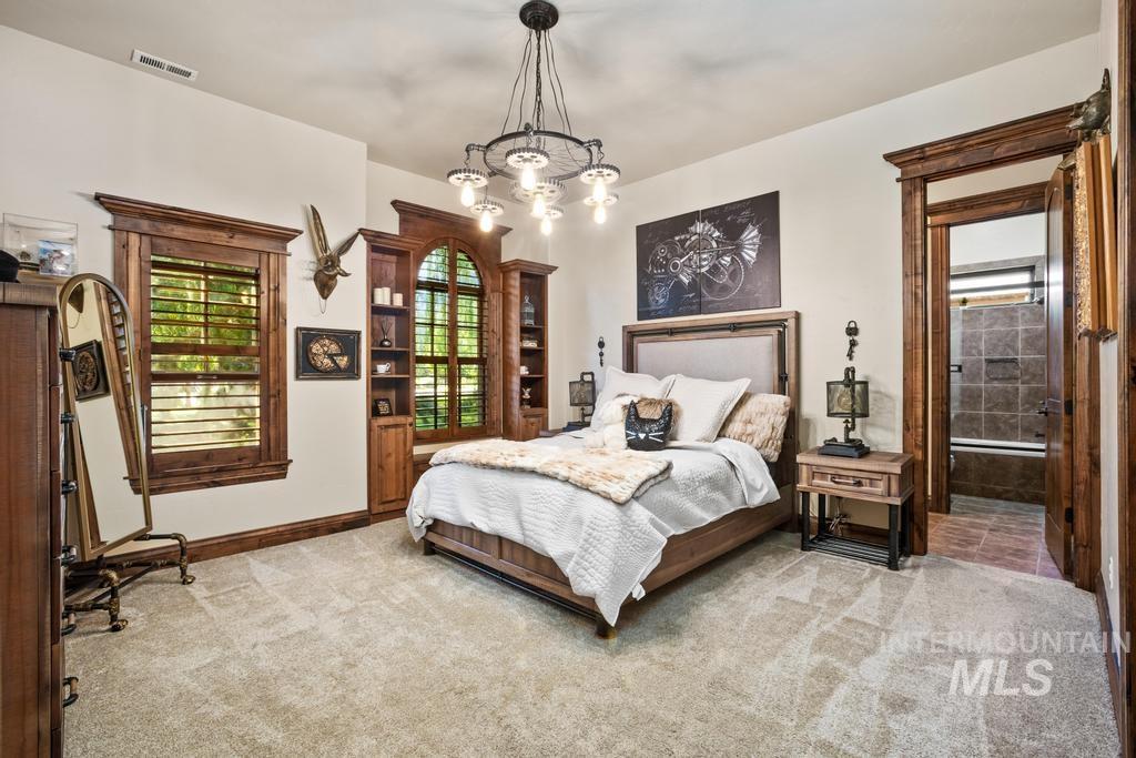 Bedroom with light-toned wall paint and textured carpeting