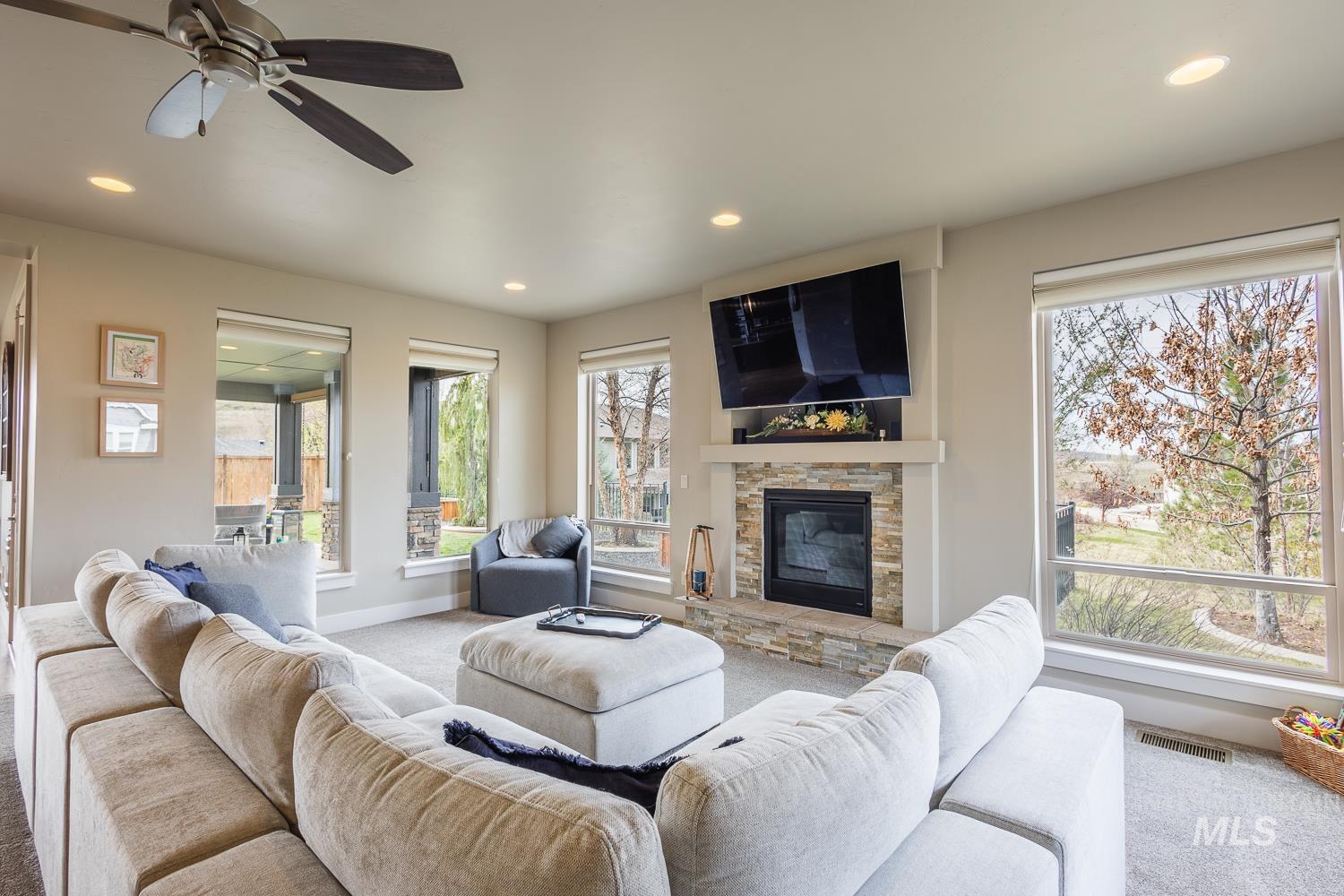 Living room with carpet floors, a ceiling fan, recessed lighting, and a fireplace