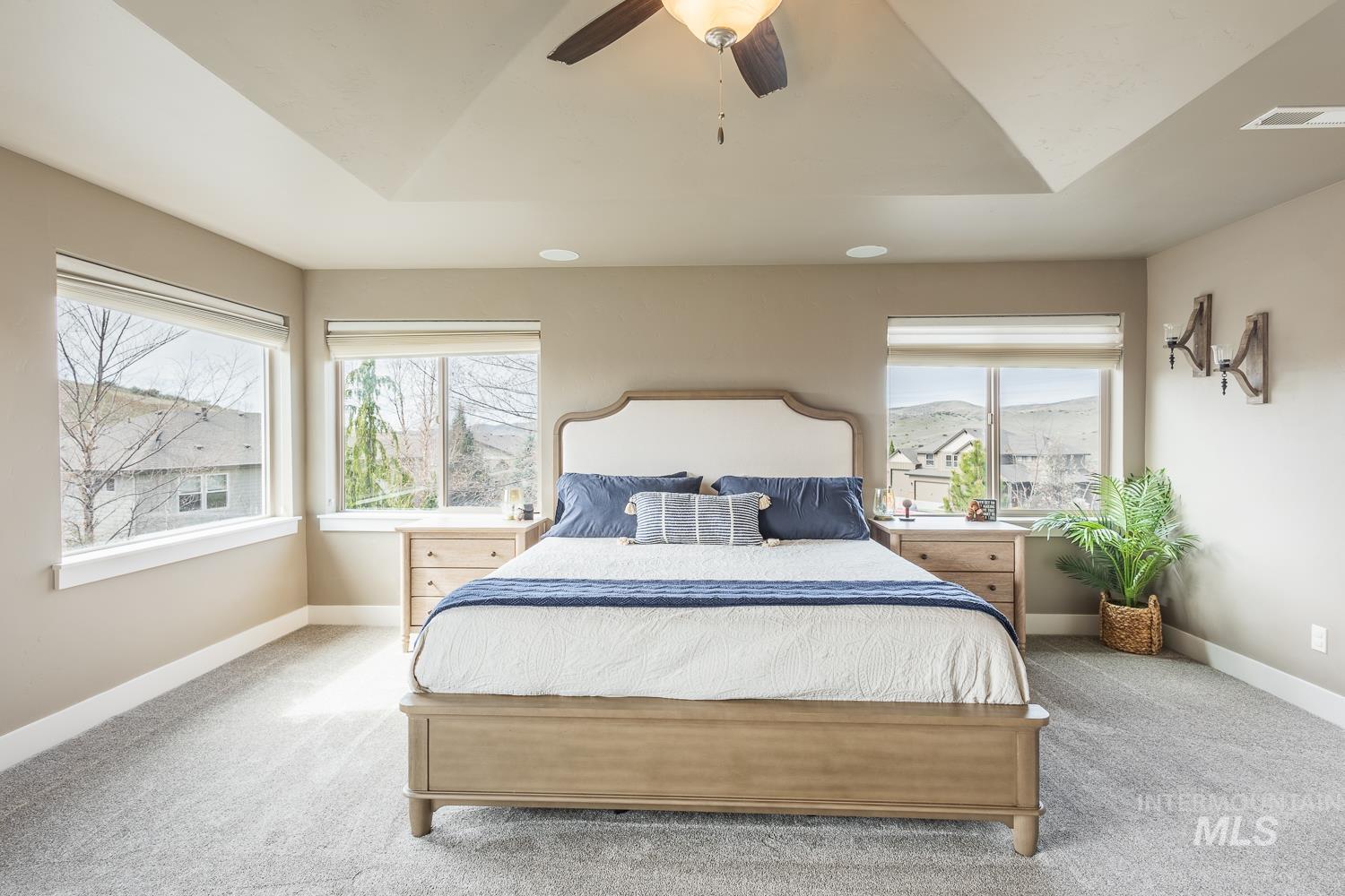 Bedroom with light colored carpet, a ceiling fan, and lofted ceiling