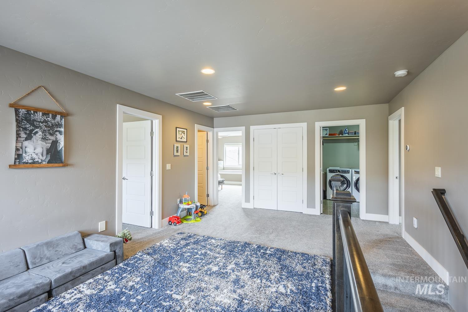 Bedroom with washer and dryer, light colored carpet, and recessed lighting