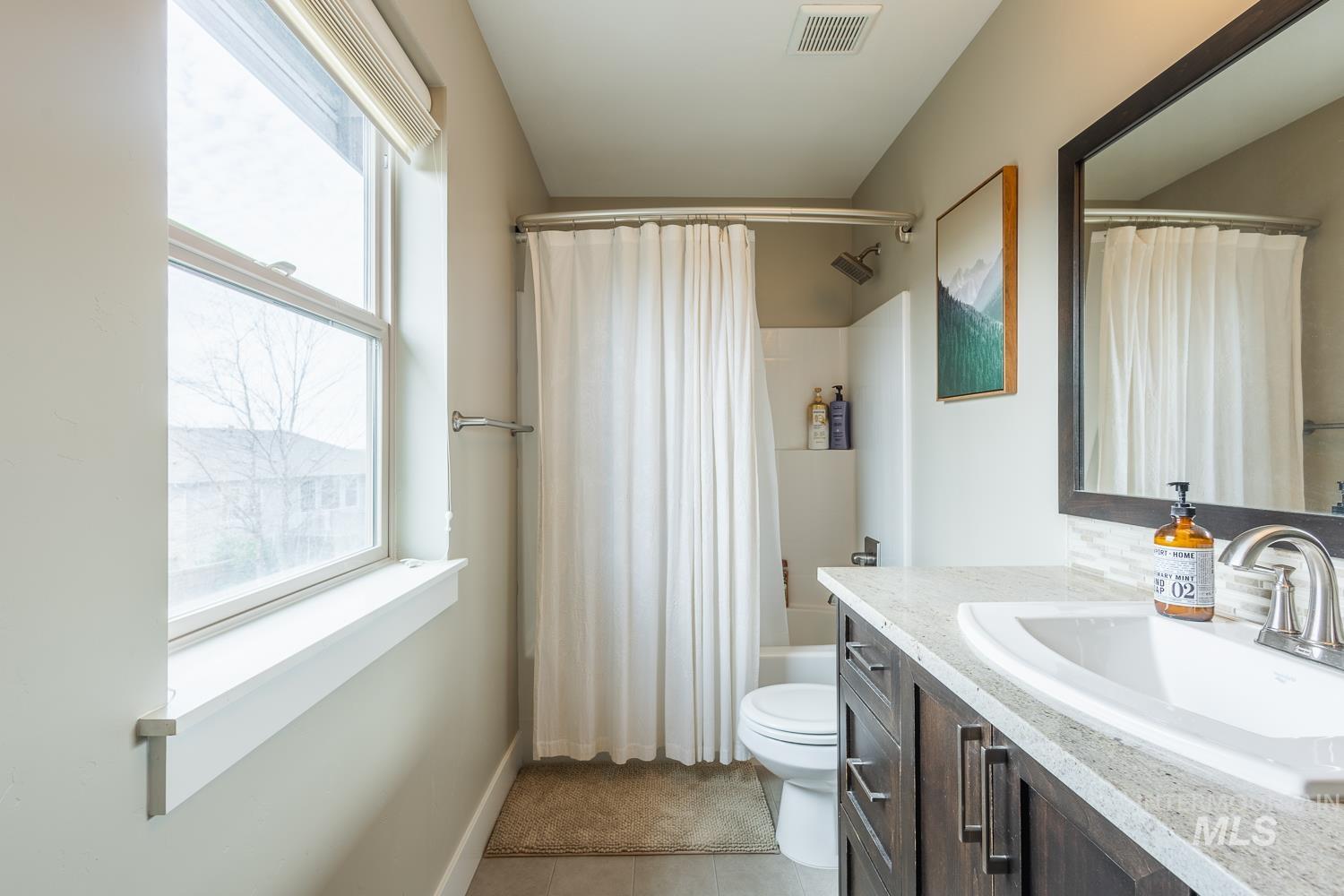 Full bathroom with vanity, shower / bath combo, and light tile patterned flooring