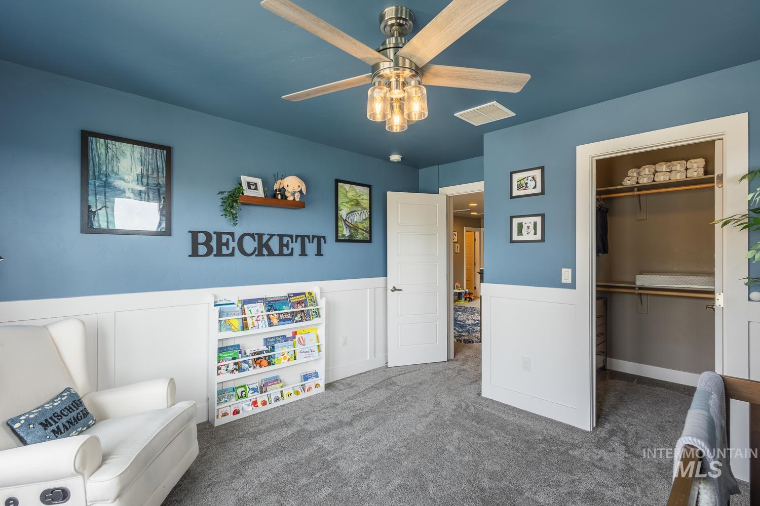 Game room with dark carpet, wainscoting, and ceiling fan