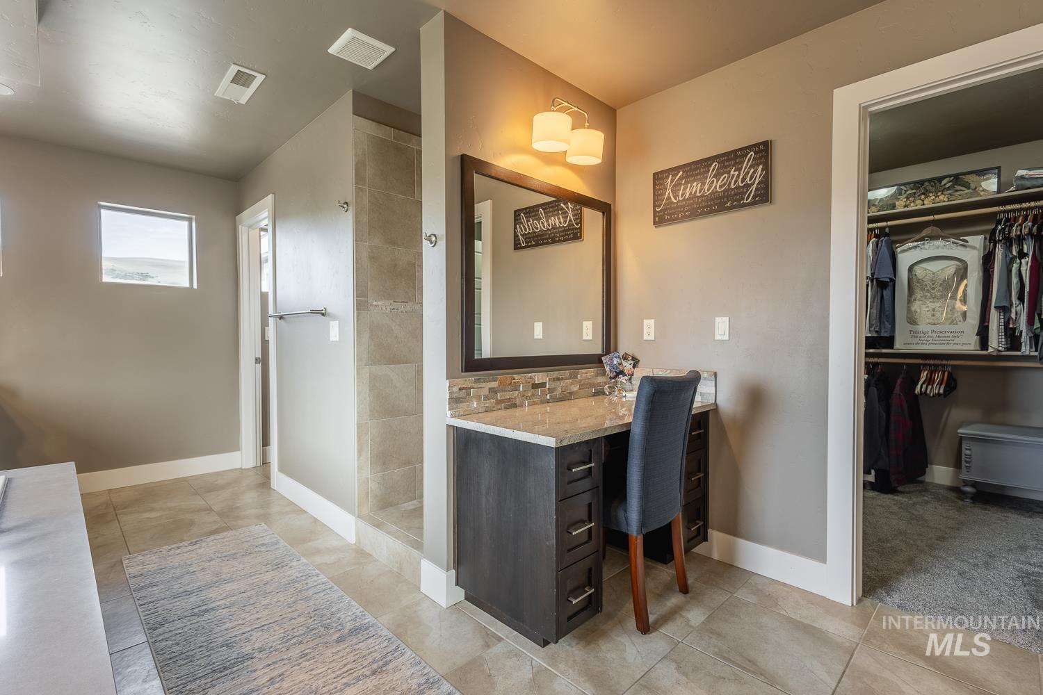 Full bathroom featuring vanity, a walk in closet, light tile patterned flooring, and walk in shower