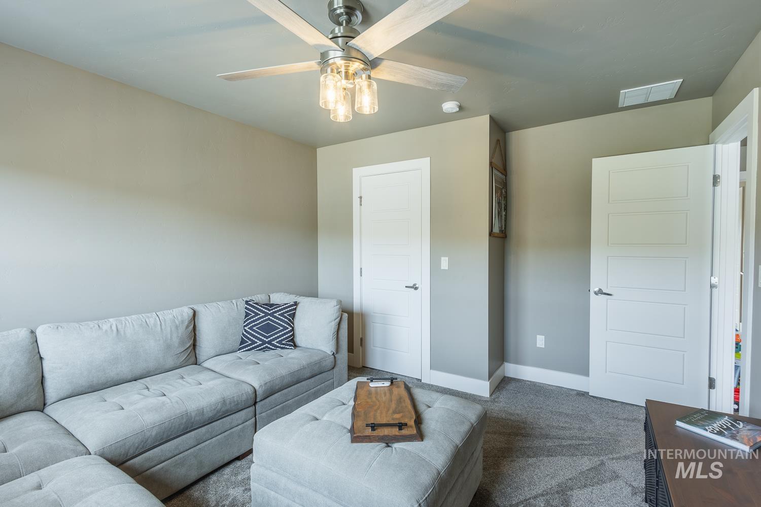Carpeted living area with baseboards and a ceiling fan
