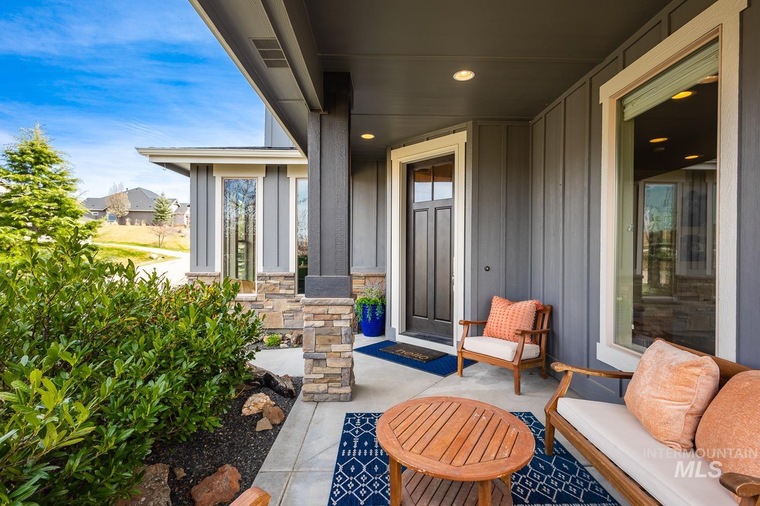 View of exterior entry featuring board and batten siding, a porch, and stone siding
