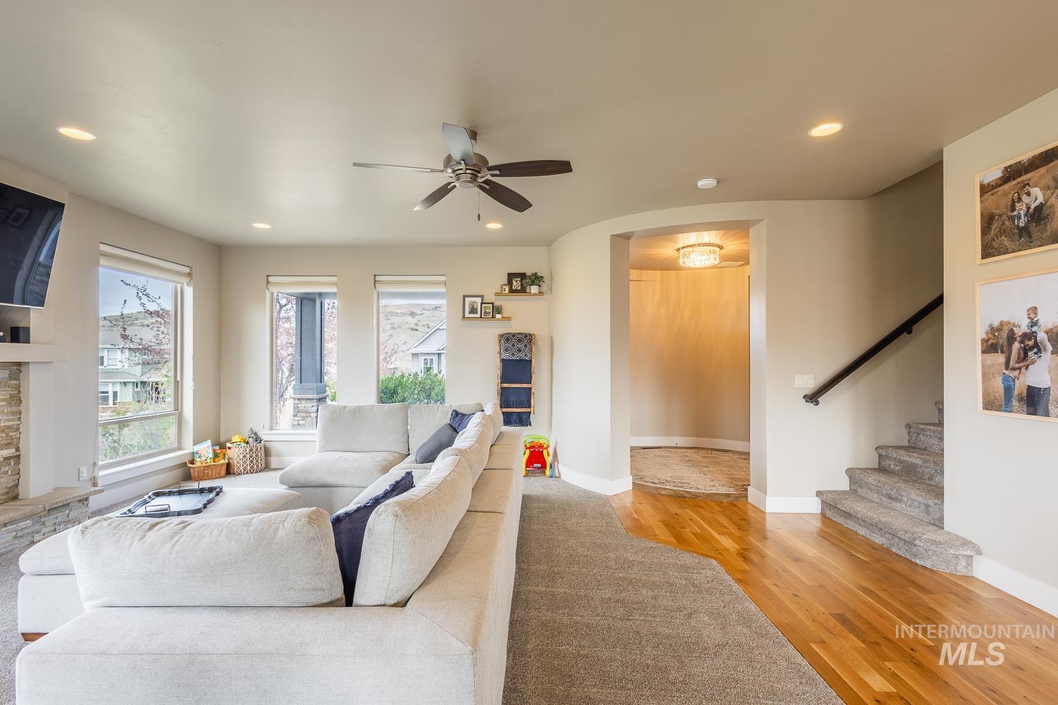 Living room featuring arched walkways, recessed lighting, light wood finished floors, and ceiling fan