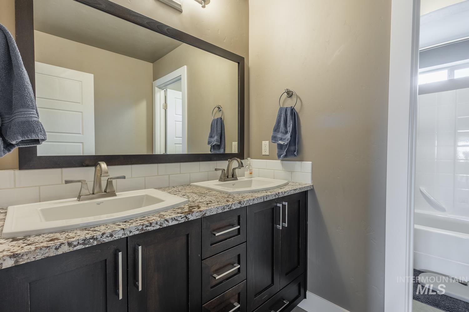 Full bath with double vanity and baseboards