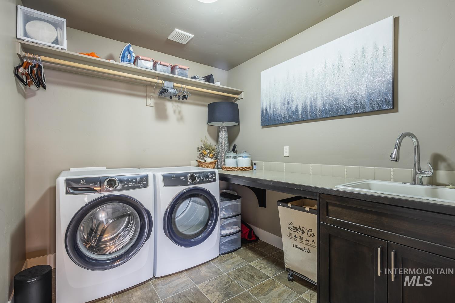 Laundry room featuring stone finish flooring and washer and dryer