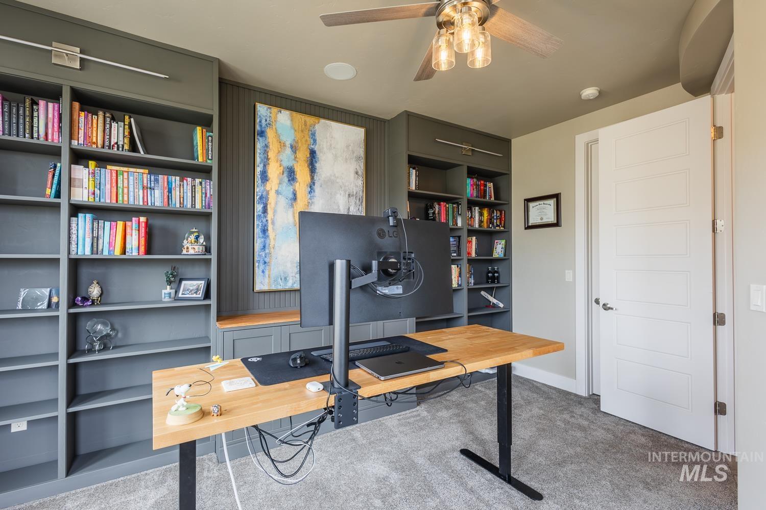 Office space with light carpet and a ceiling fan