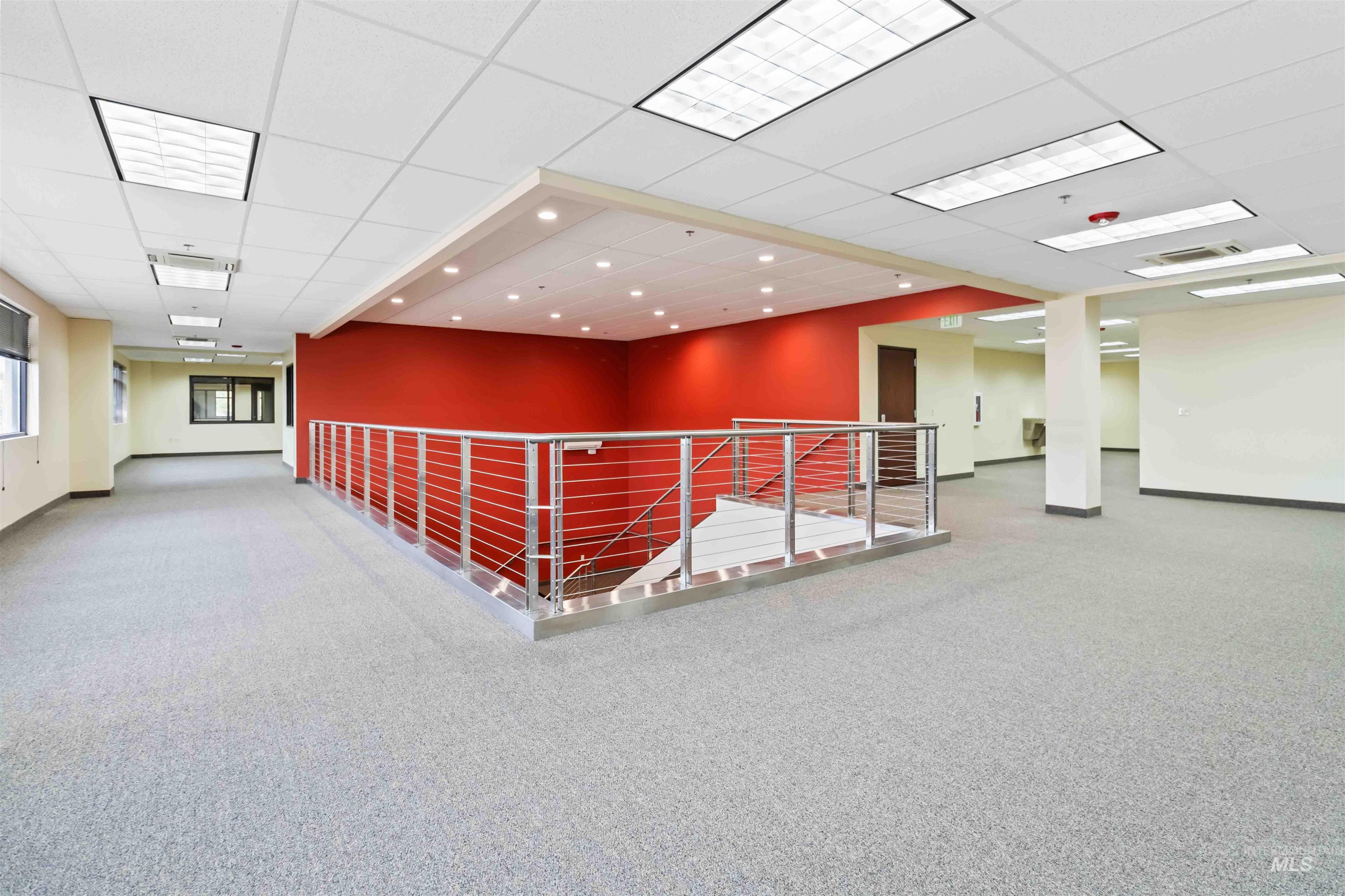 Corridor with an upstairs landing, carpet floors, a drop ceiling, and recessed lighting