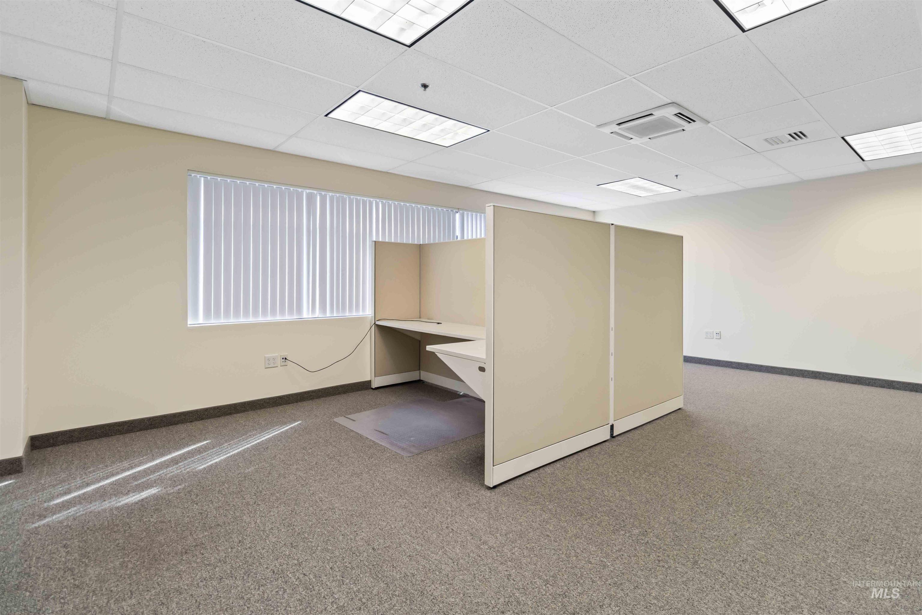 Unfurnished office featuring a paneled ceiling, built in study area, and cooling unit