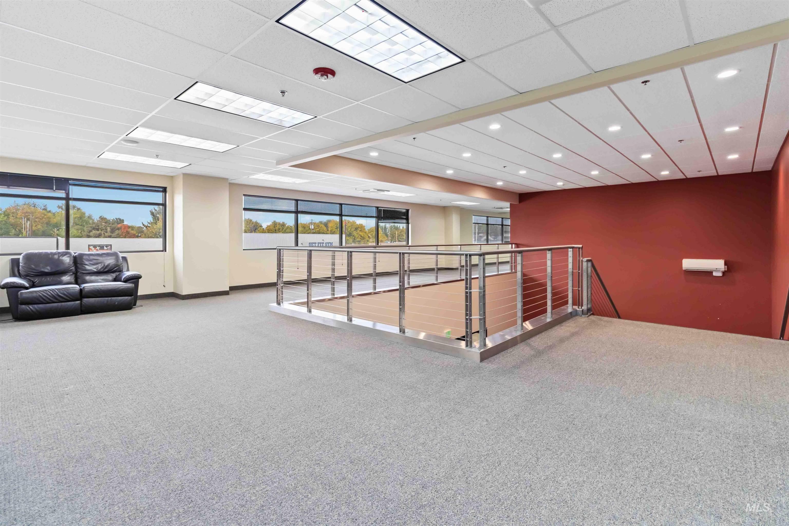 Interior space featuring carpet floors, a paneled ceiling, and healthy amount of natural light