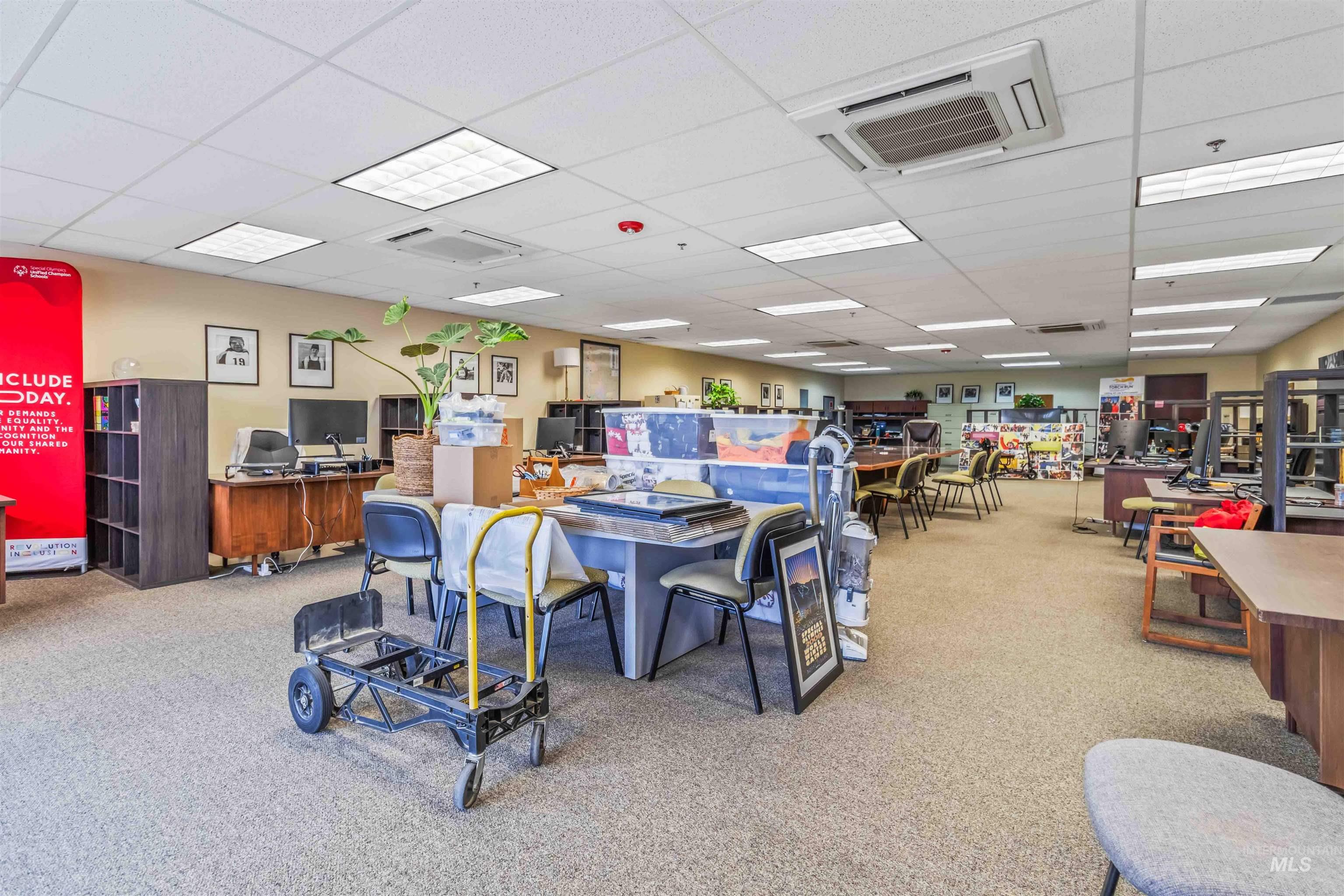 Miscellaneous room with cooling unit, a drop ceiling, and an office area