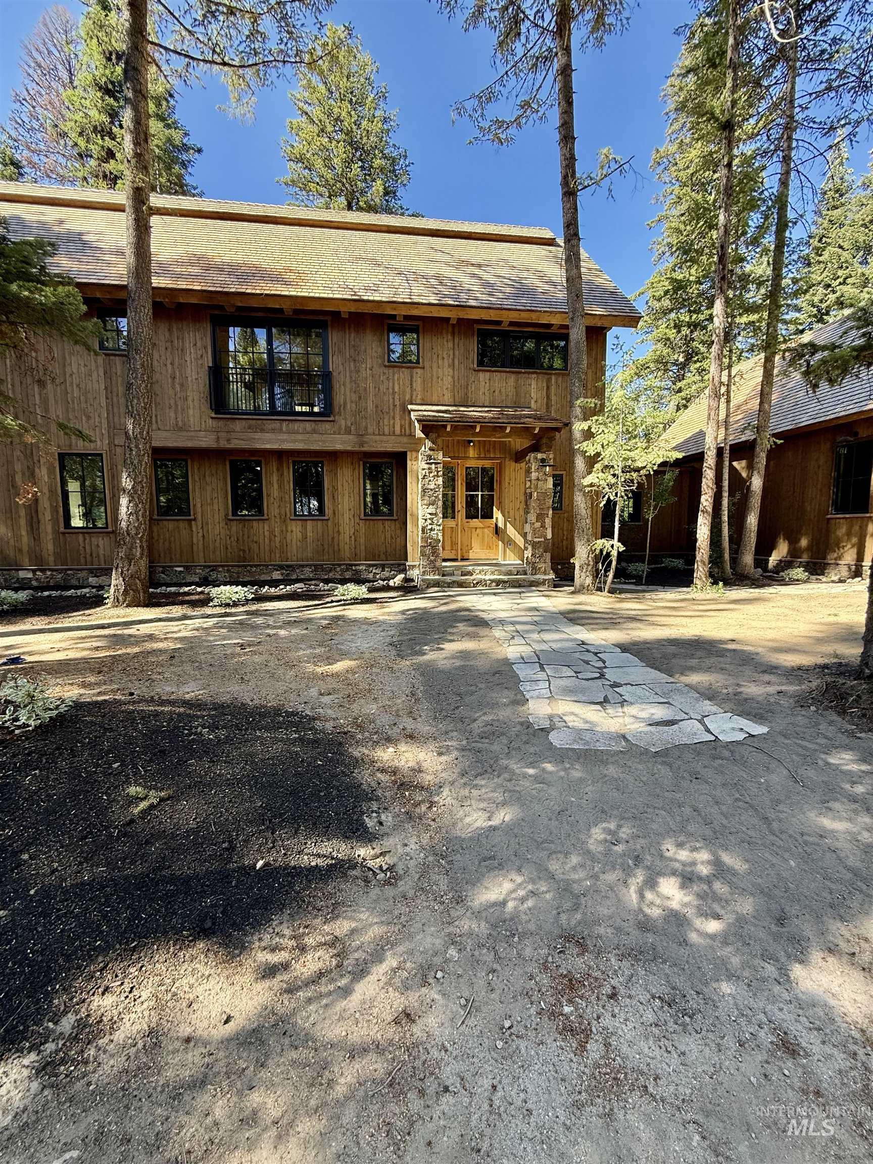 Back of house featuring a balcony and driveway