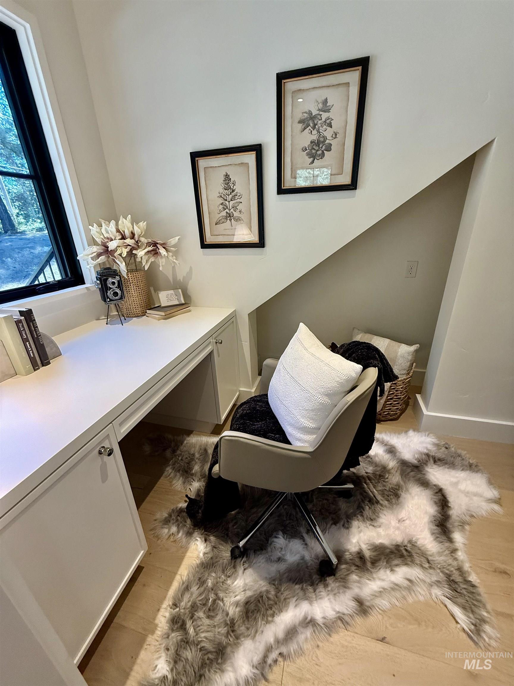 Living area featuring light wood-style flooring and built in study area