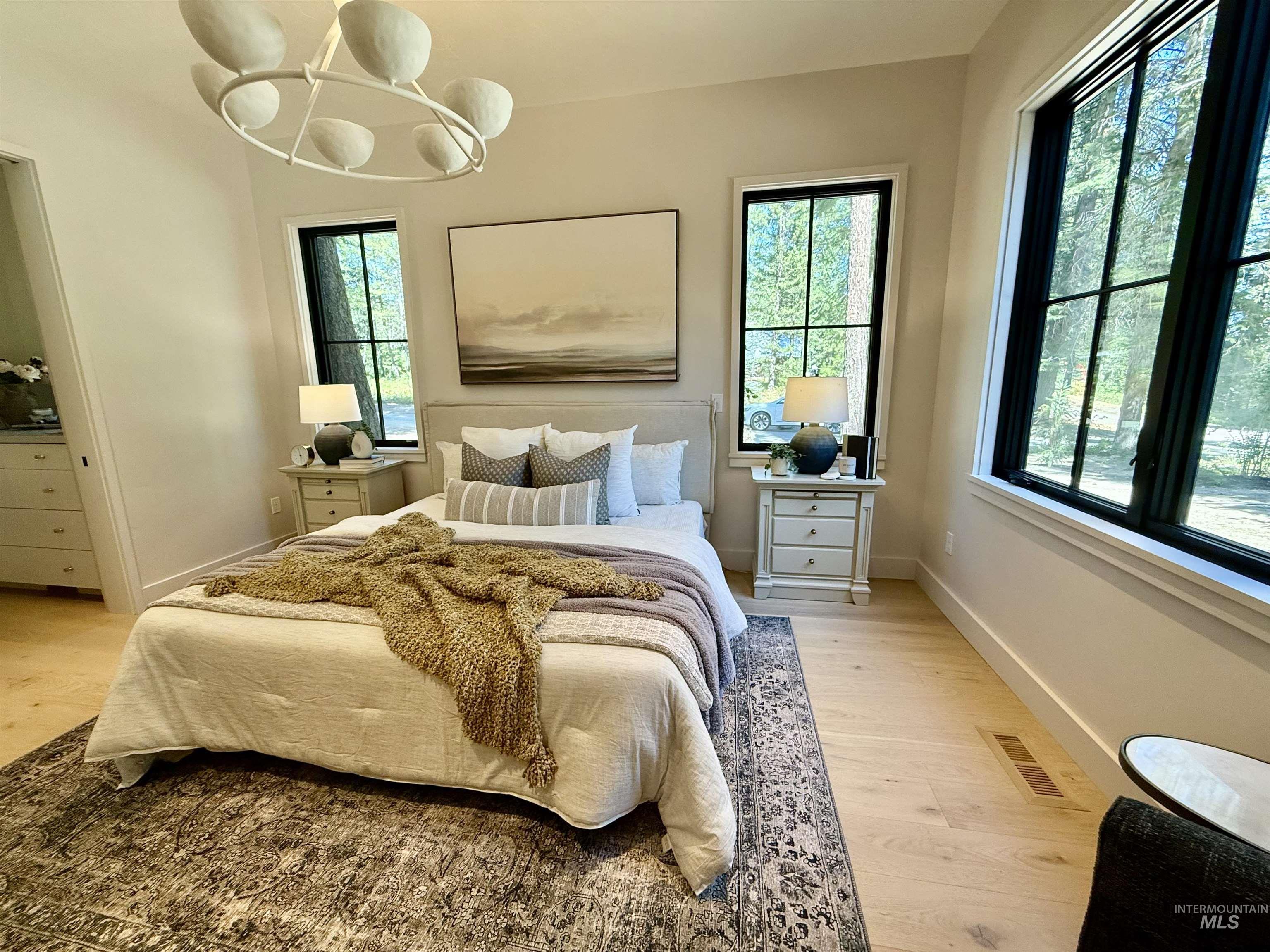 Bedroom with light wood finished floors and a chandelier