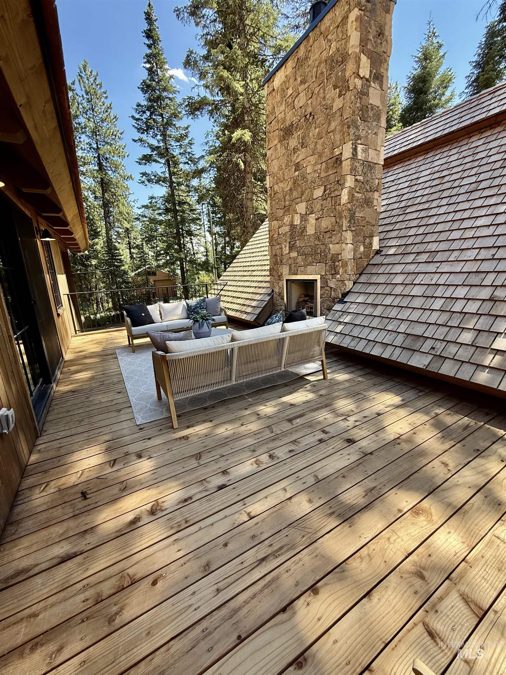 Wooden deck featuring an outdoor living space with a fireplace