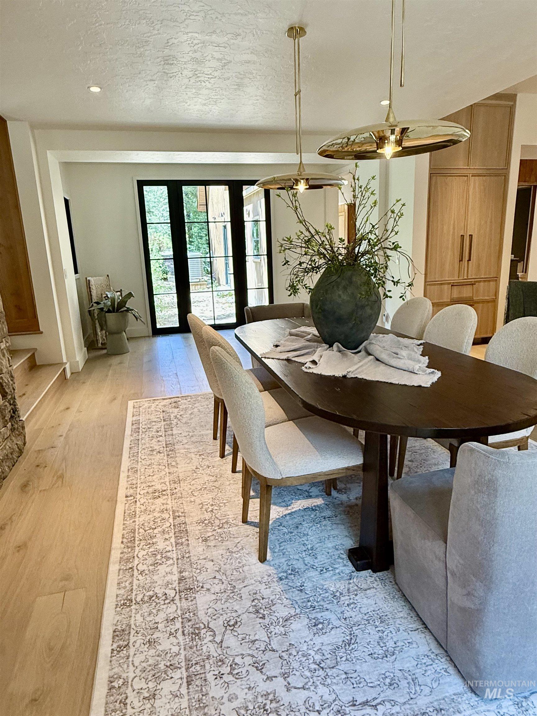 Dining room with light wood finished floors and a textured ceiling
