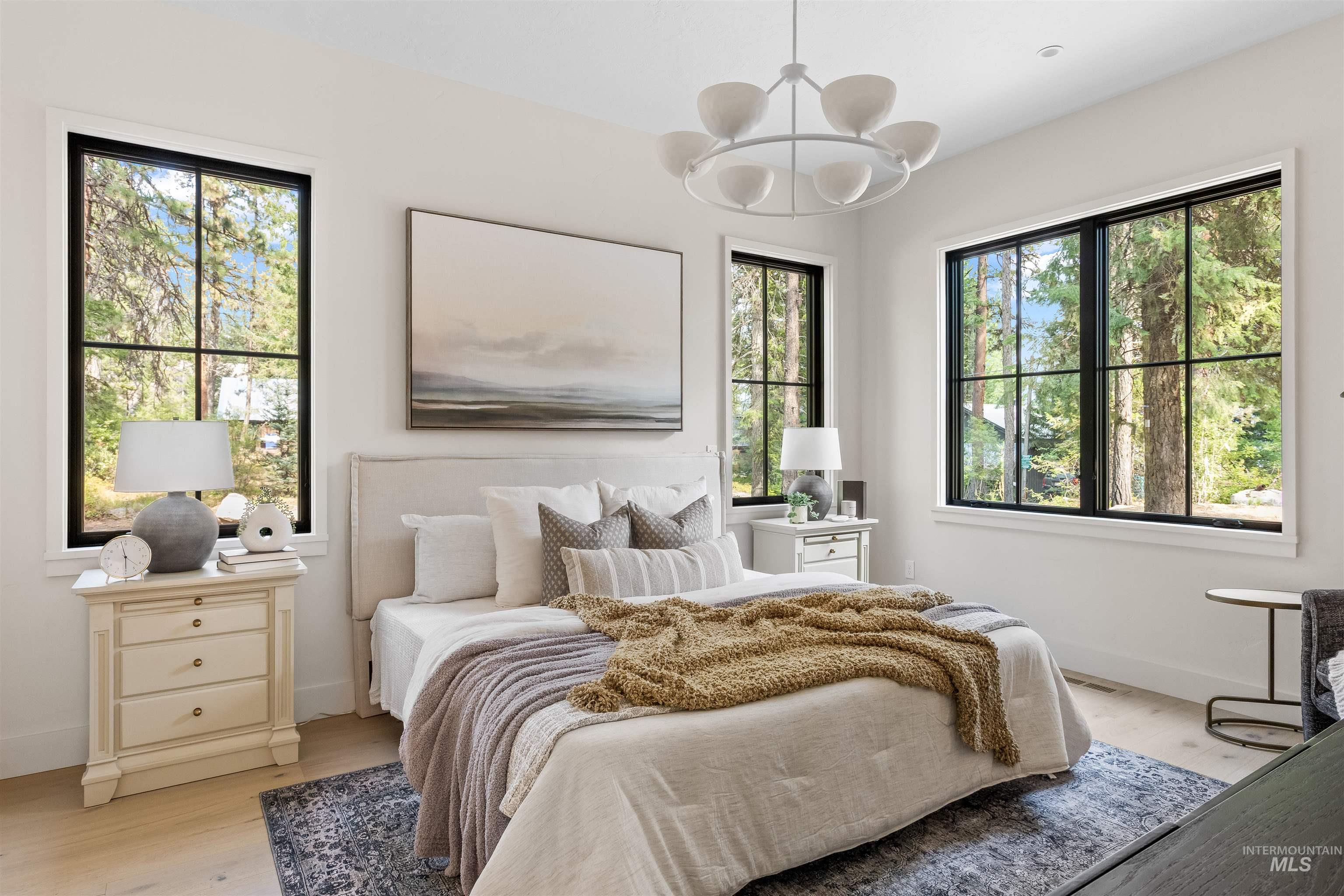 Bedroom with light wood finished floors and a chandelier