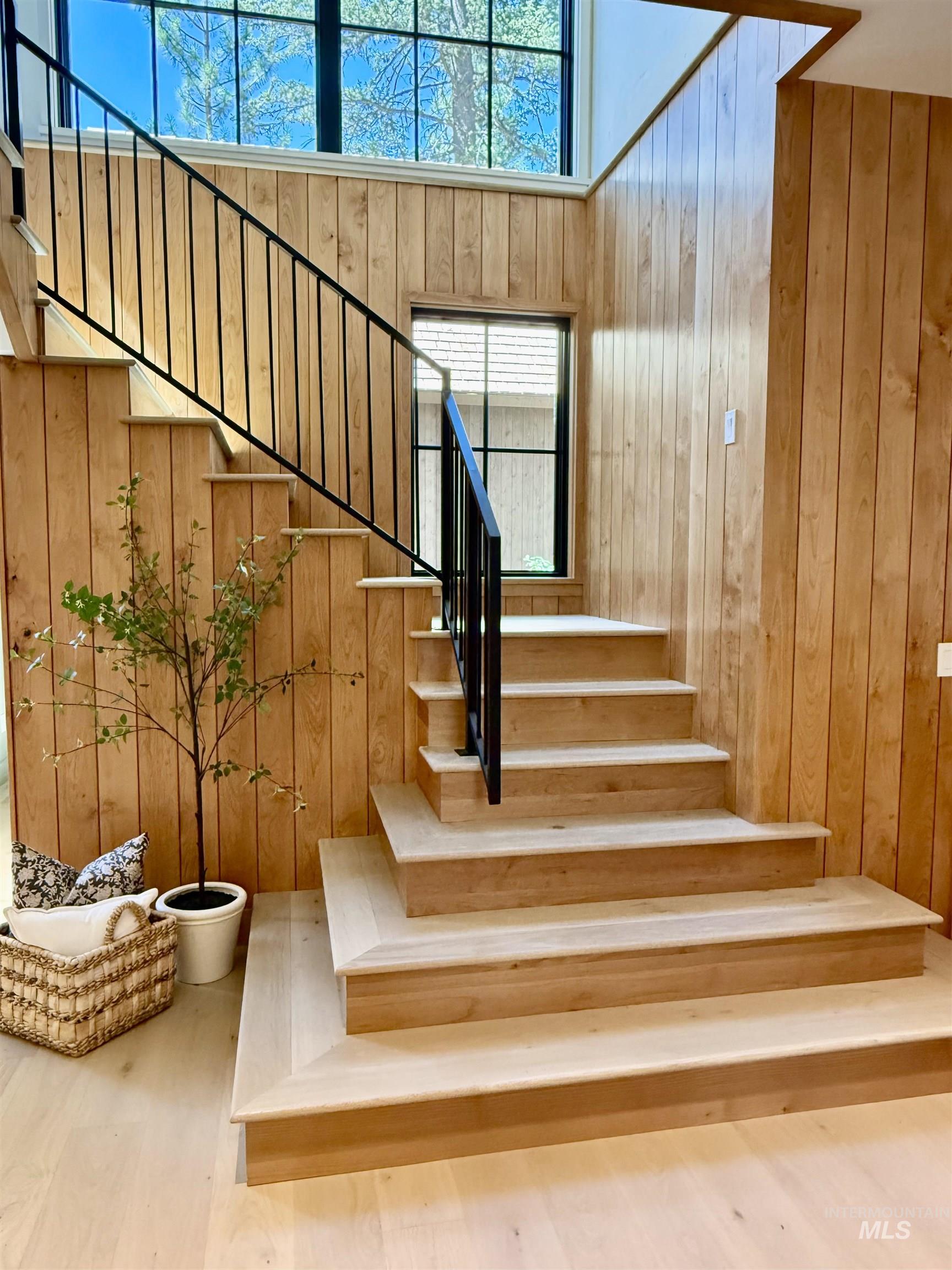 Stairway with wooden walls and wood finished floors