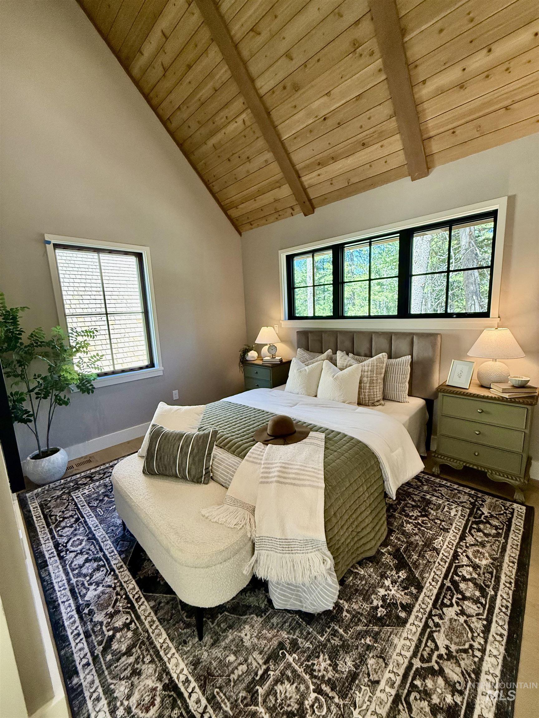 Bedroom featuring a wooden ceiling with exposed beams and high vaulted ceiling